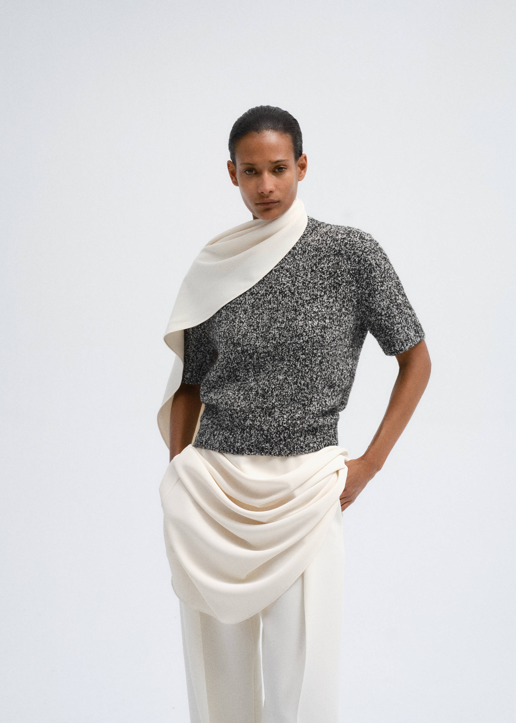 Black and white speckled short-sleeved knit jersey with a draped white scarf.