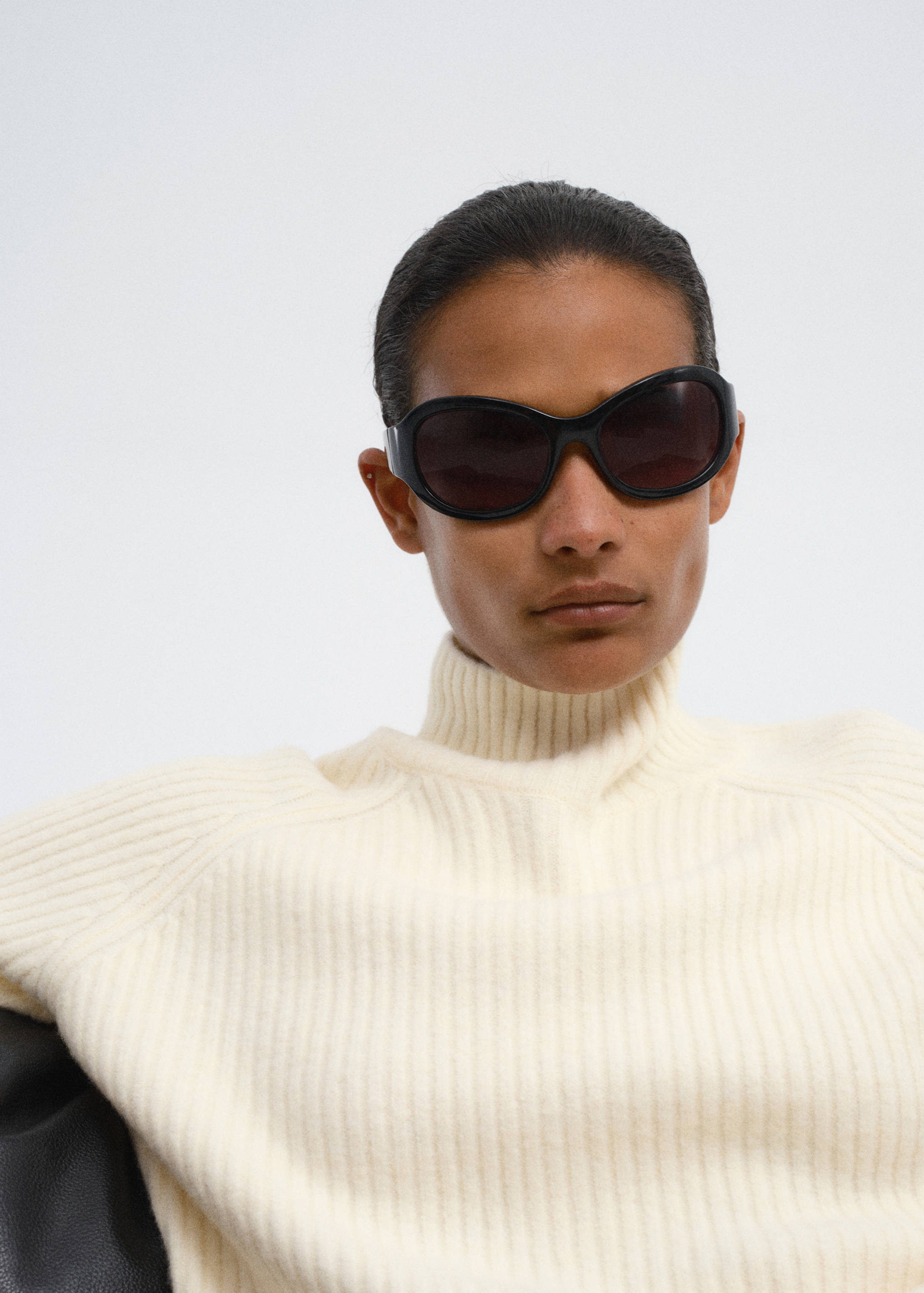 Cream ribbed jersey with a high neck, shown in a close-up frontal view.