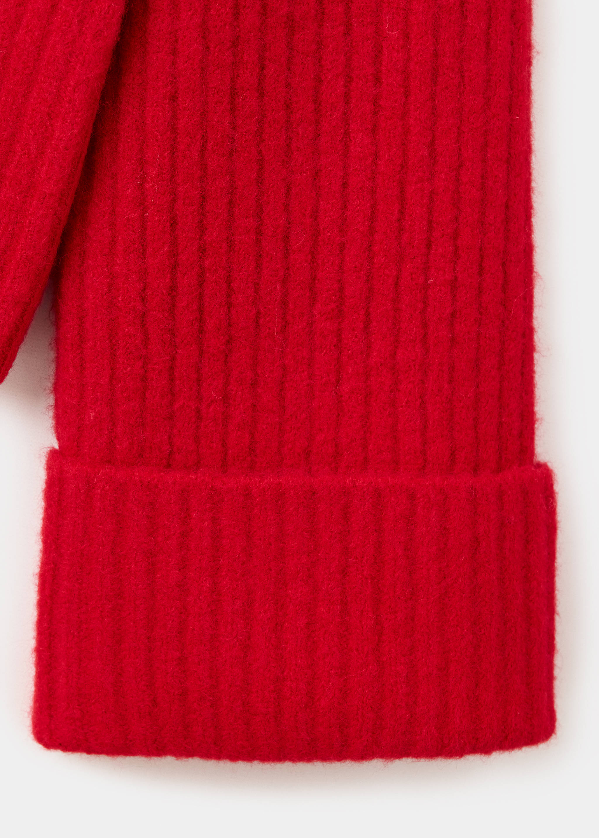 Close-up of a red ribbed knit sweater sleeve with a folded cuff.