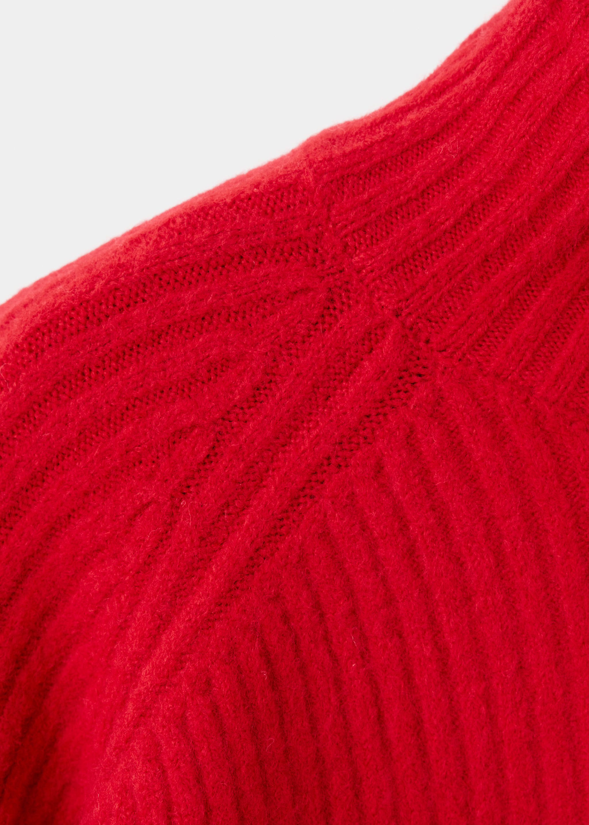 Close-up of the red knitted jumper fabric showing texture.