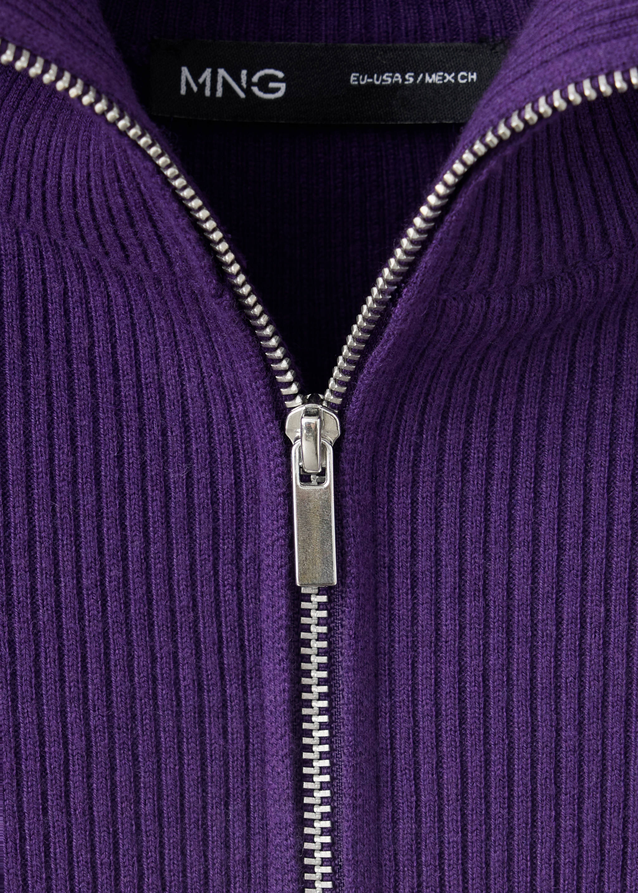 Close-up of a purple knitted jumper with a ribbed high collar and silver zip.