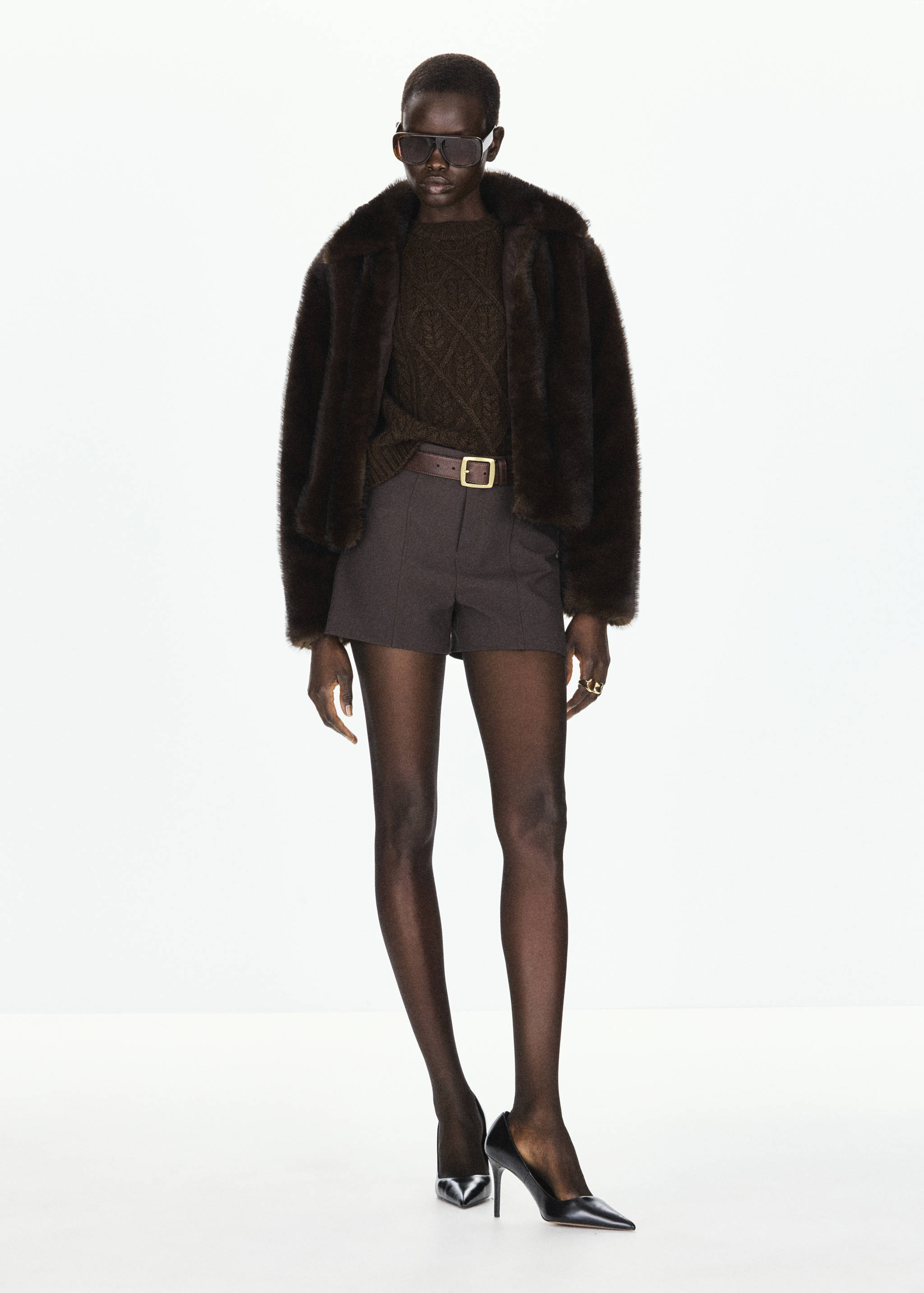 Dark brown cable-knit jersey layered with a dark brown faux-fur jacket and shorts.