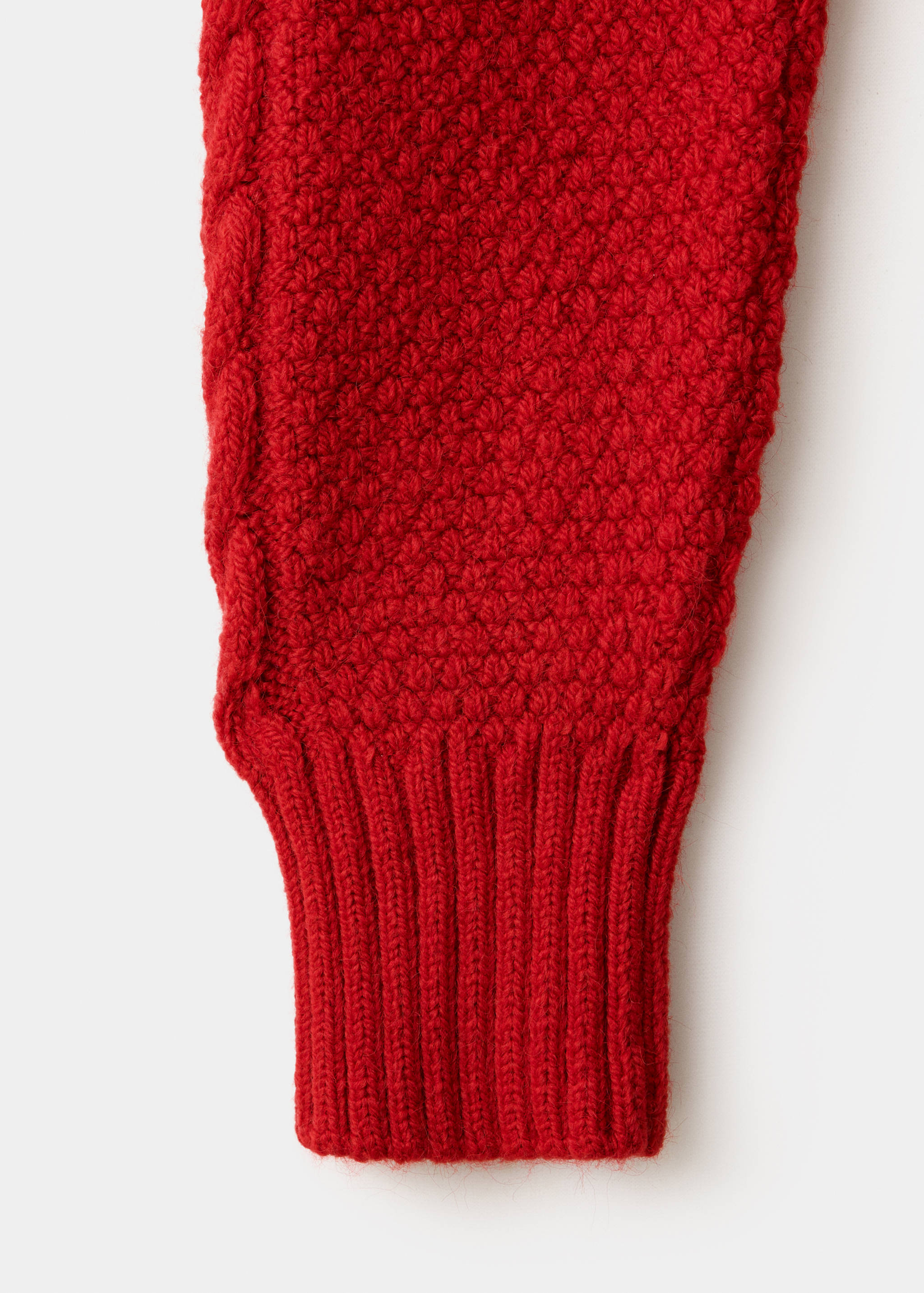Red jersey sleeve texture detail with cable knit and ribbed cuff.