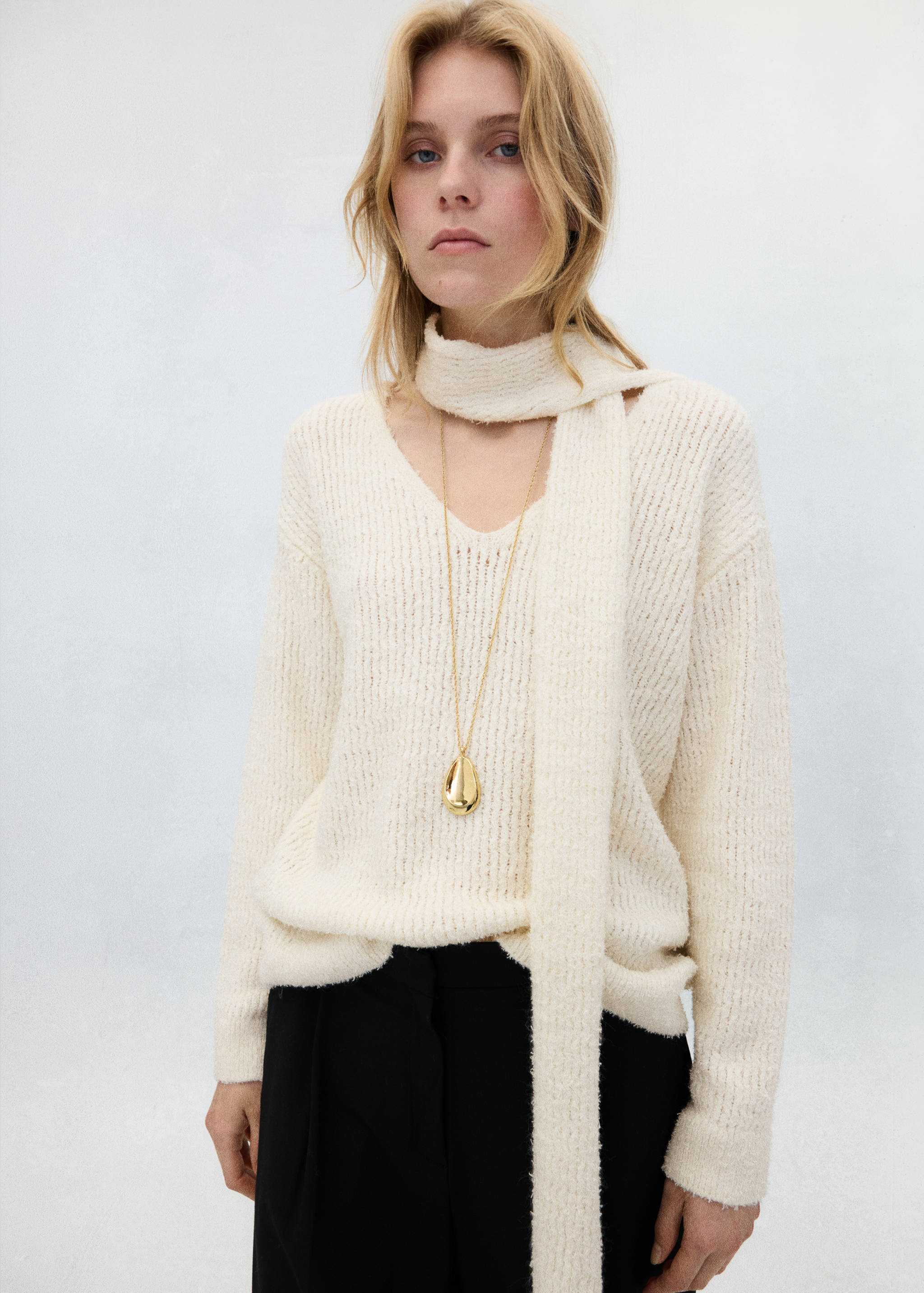 Off-white V-neck knitted jersey with an integrated scarf and long gold necklace.