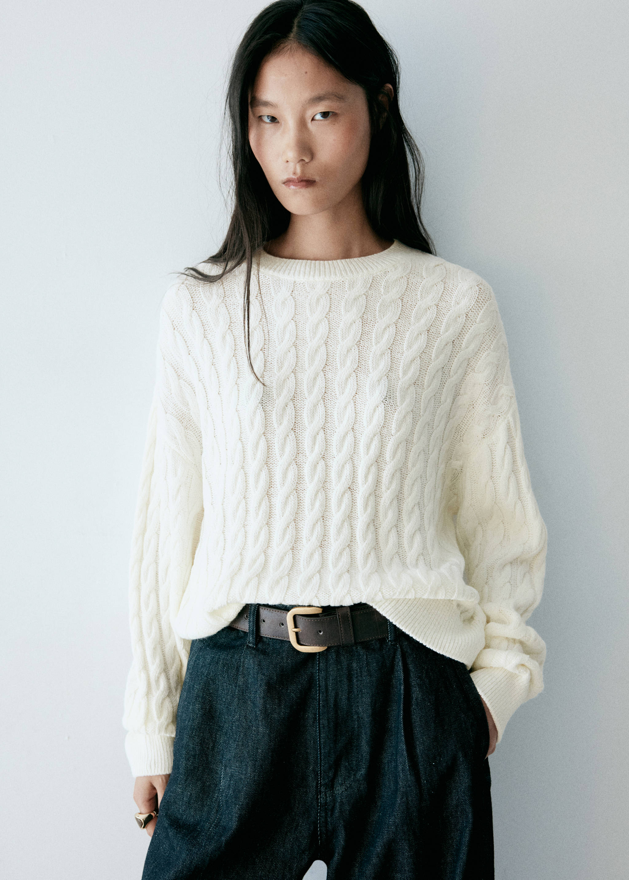 Off-white cable-knit jersey with a round neckline and long sleeves.