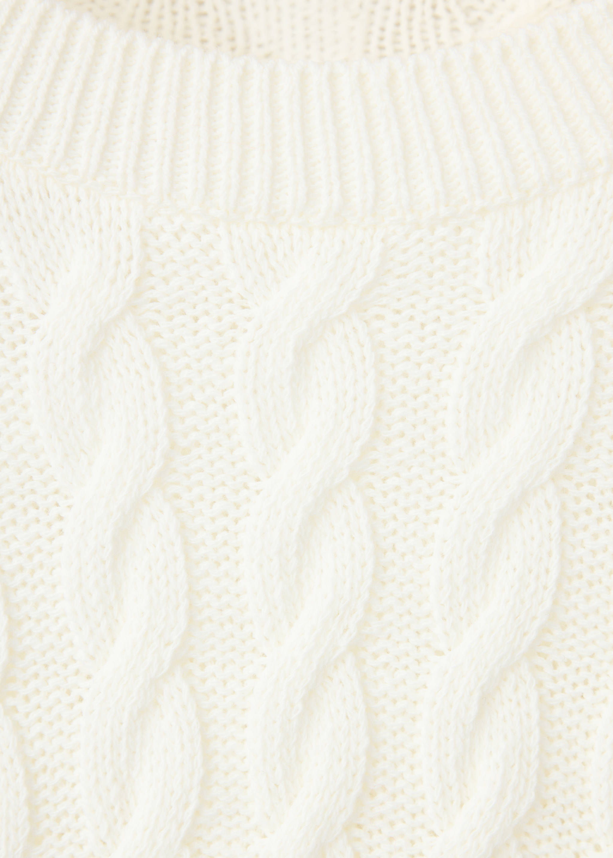 Close-up of an off-white cable-knit sweater with a ribbed round neckline.