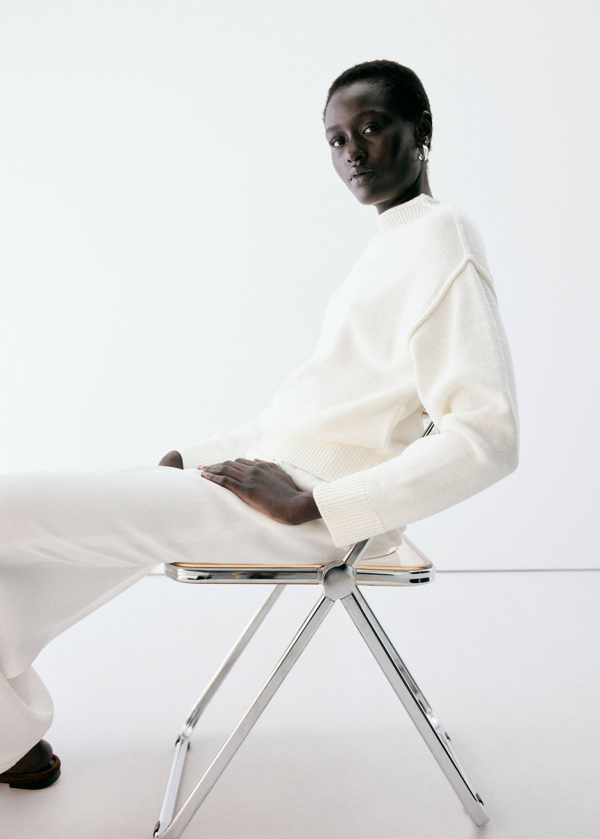 Cream knit jersey with a mock neck and ribbed trims.