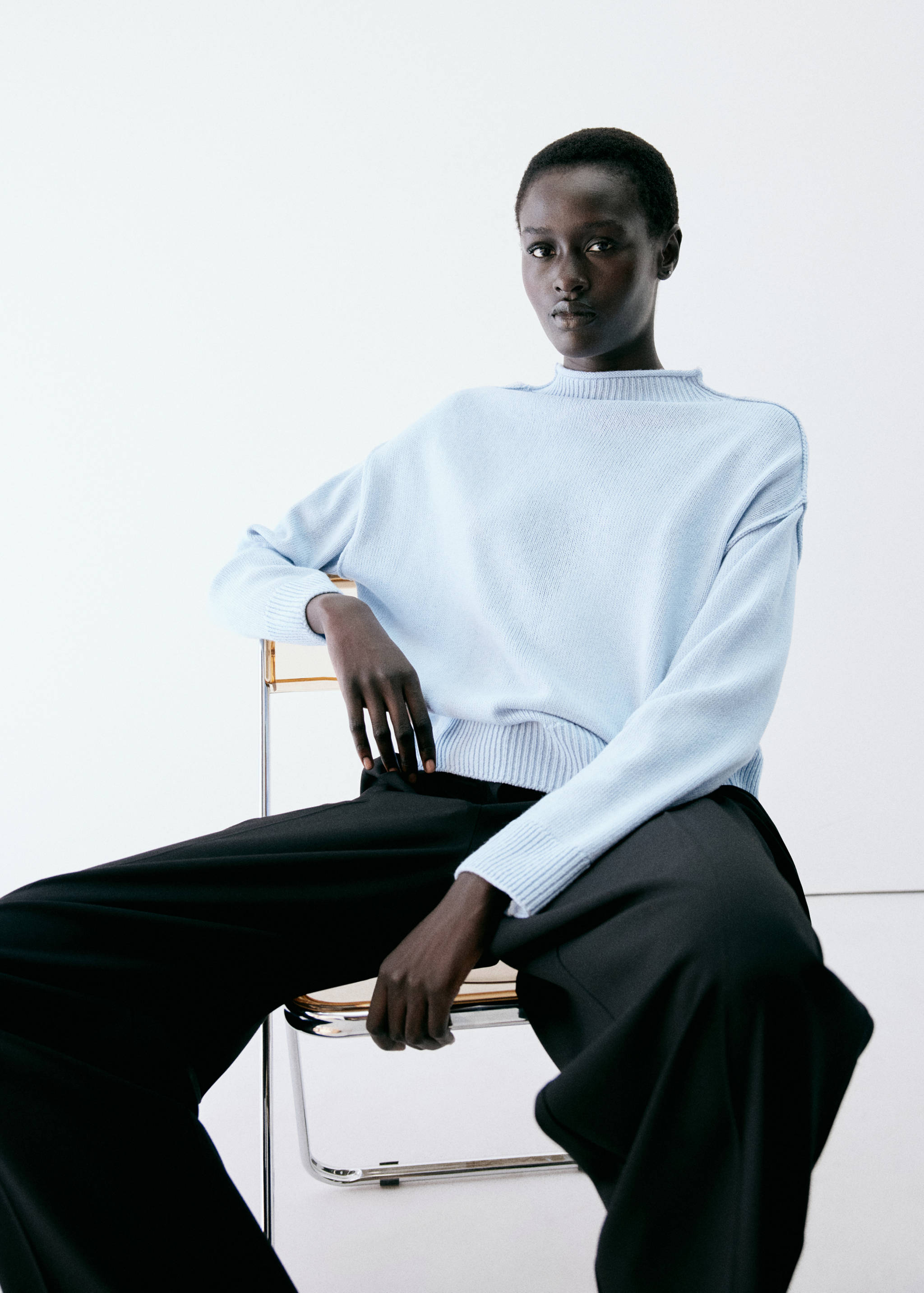 Pale blue knitted jersey with a mock neck and relaxed fit.