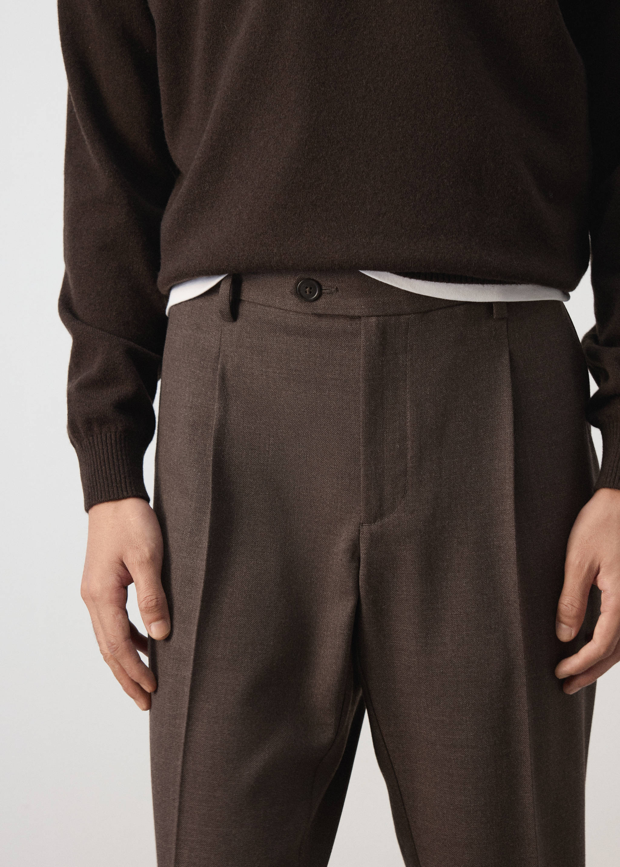 Pantalón de traje plisado en marrón oscuro con trabillas para el cinturón.