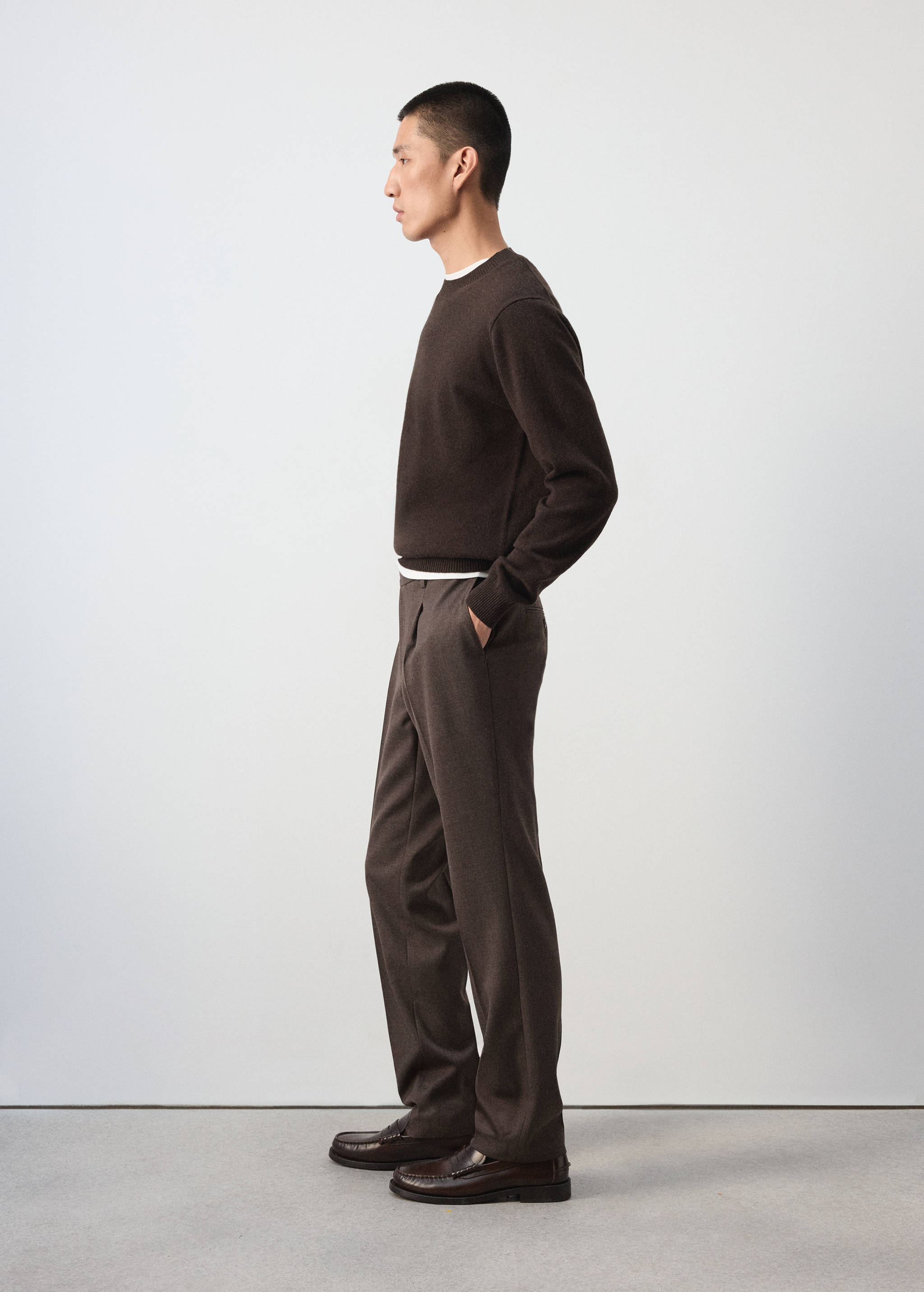 Pantalones rectos de color marrón combinados con un jersey marrón y mocasines oscuros de piel.