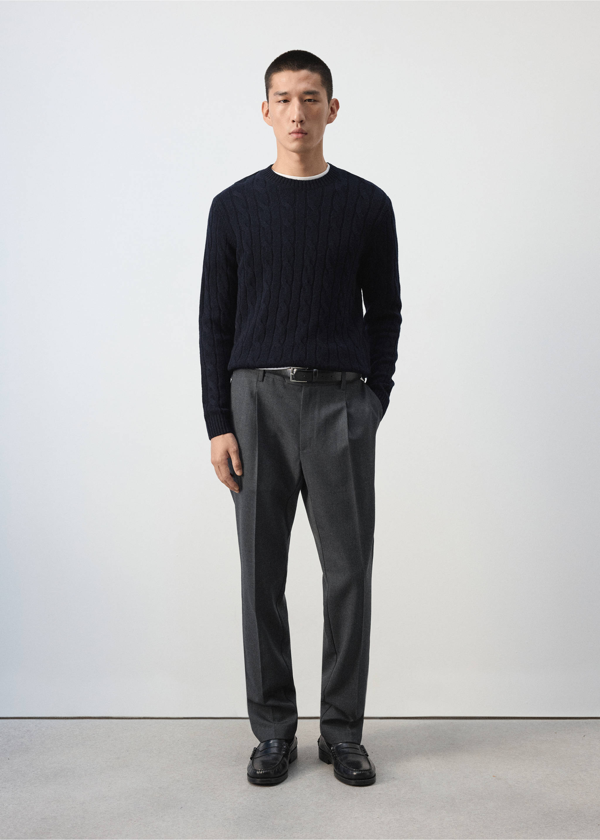 Dark grey pleated trousers worn with a navy cable-knit sweater., Charcoal. Ref: 37007888-00.