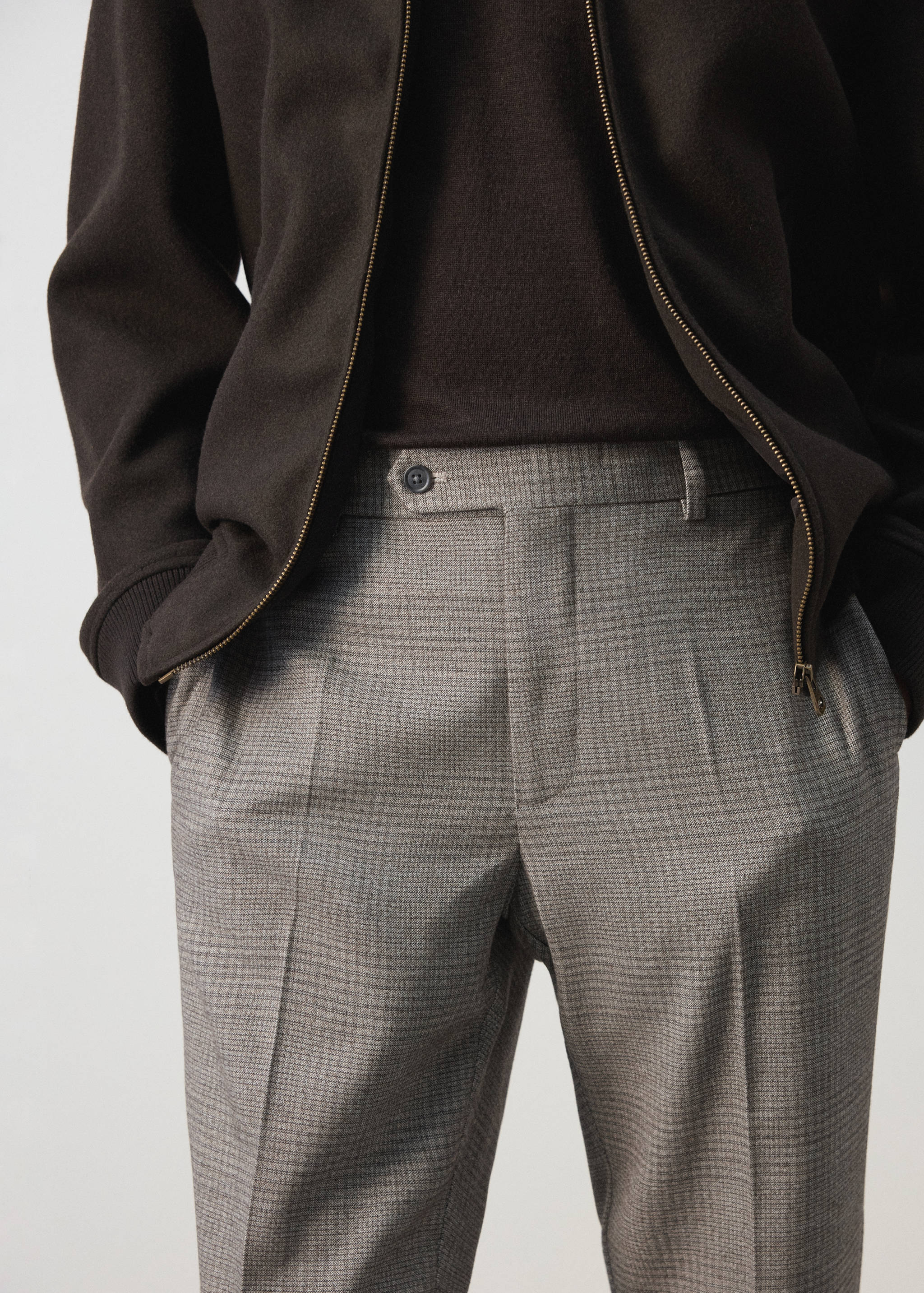 Grey patterned check trousers featuring a waistband with belt loops and front pleats.