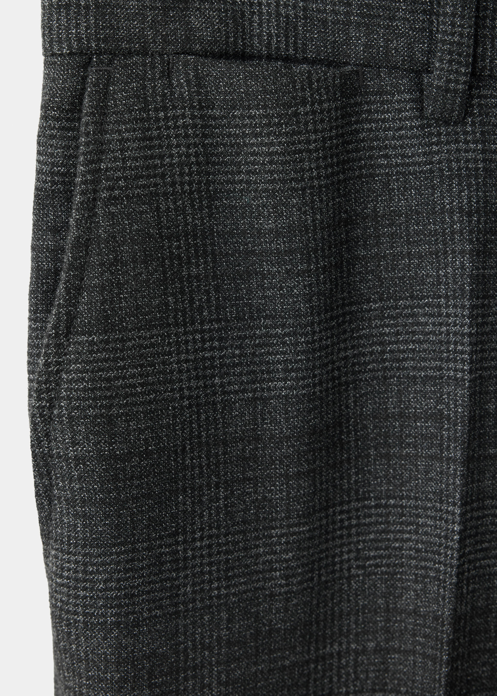 Close-up of dark grey checked trousers fabric detail.