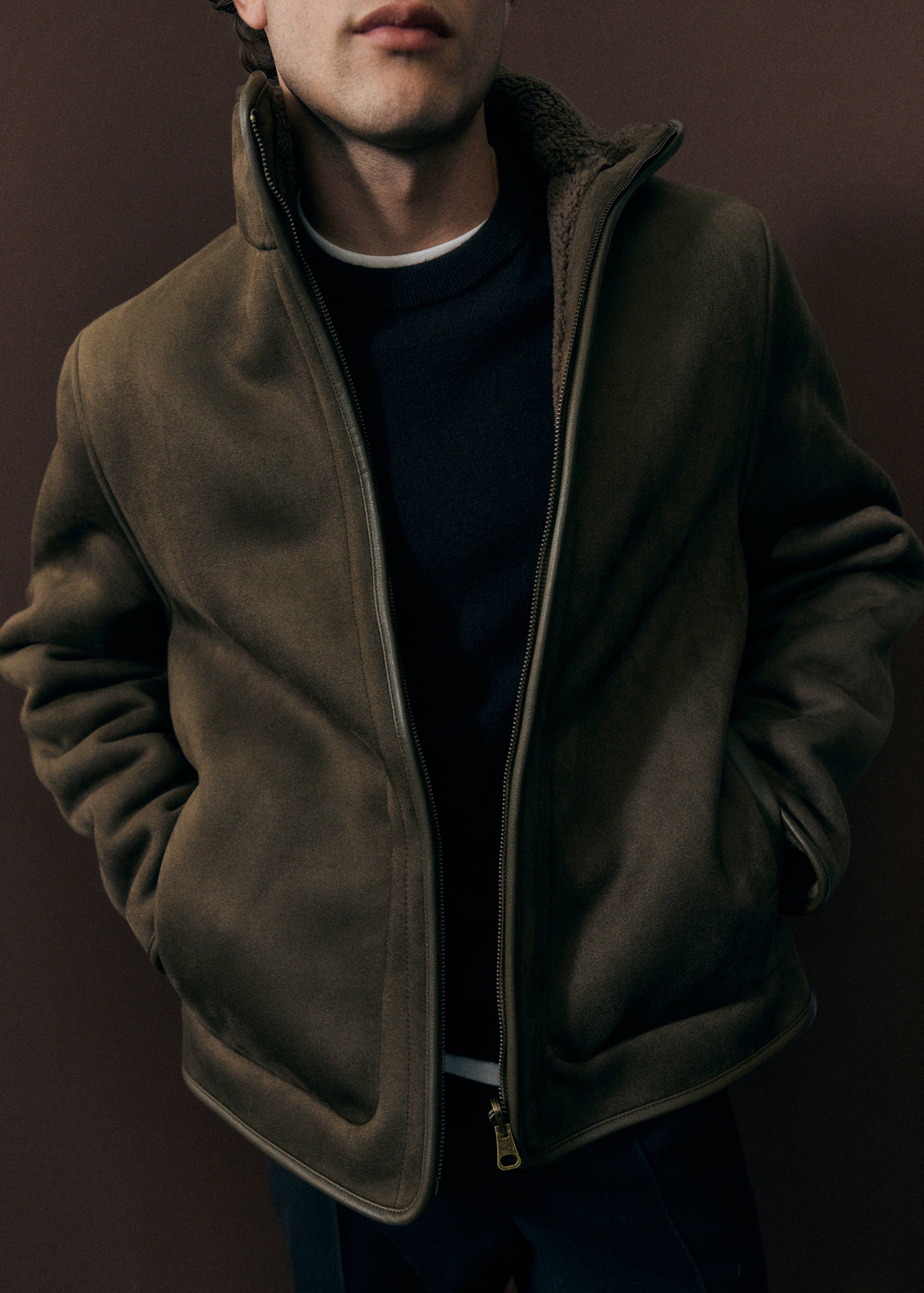 Olive green jacket with a high collar and shearling lining.