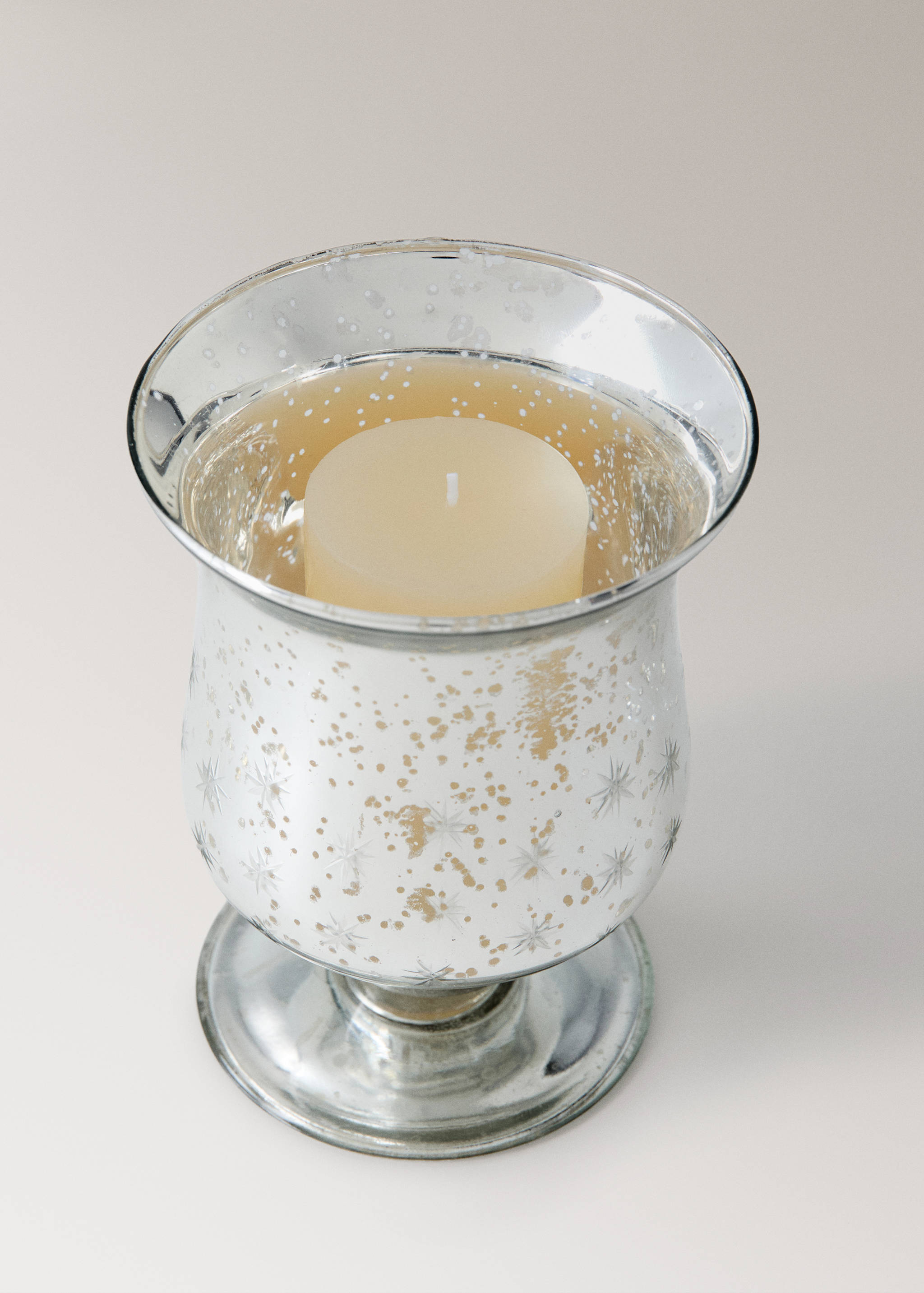 Silver mercury glass candleholder with starburst pattern and pillar candle.