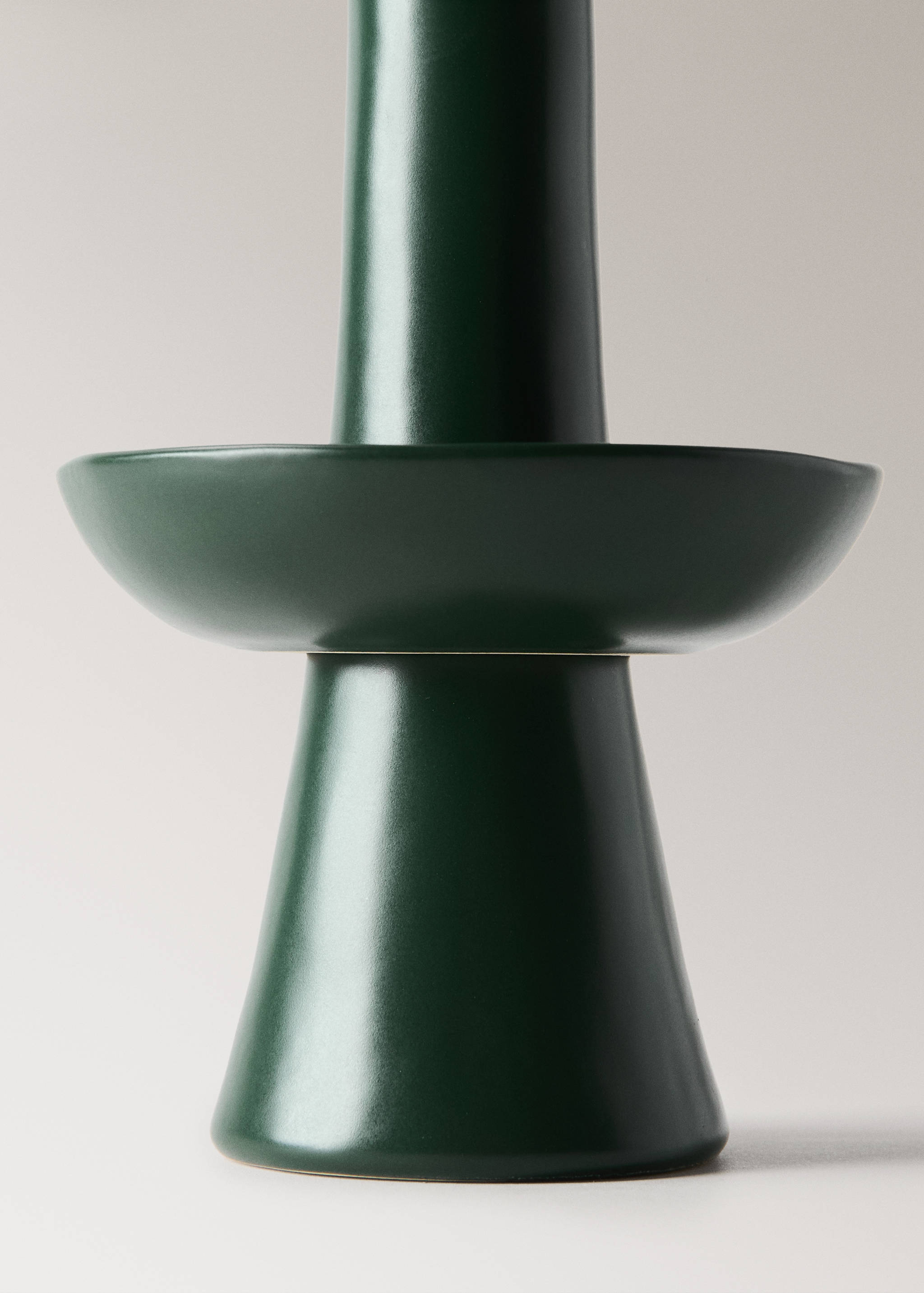 Dark green ceramic candle holder with a tapered base and wide circular tray.
