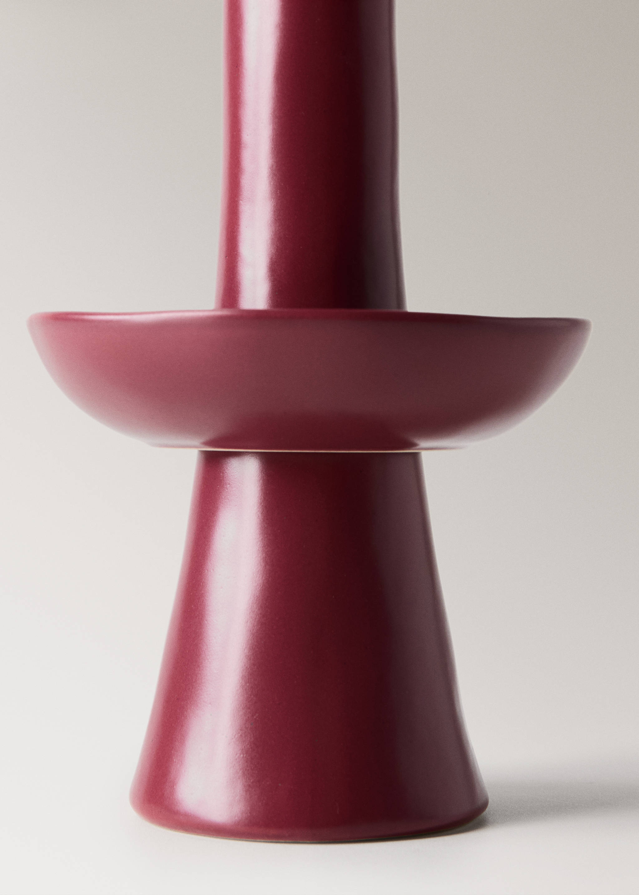 Burgundy ceramic candle holder close-up.
