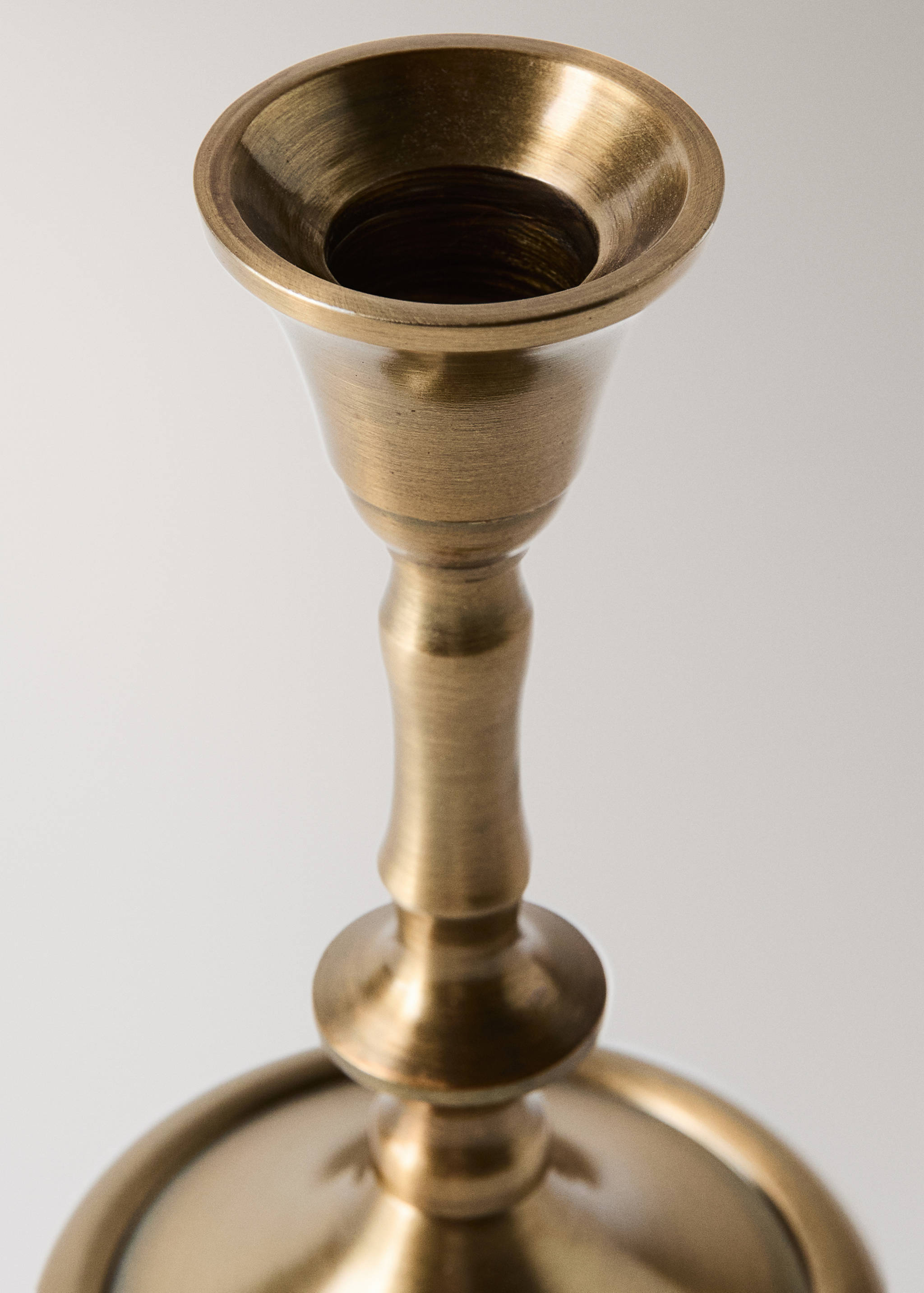 Close-up of a brass-finished metal candle holder.