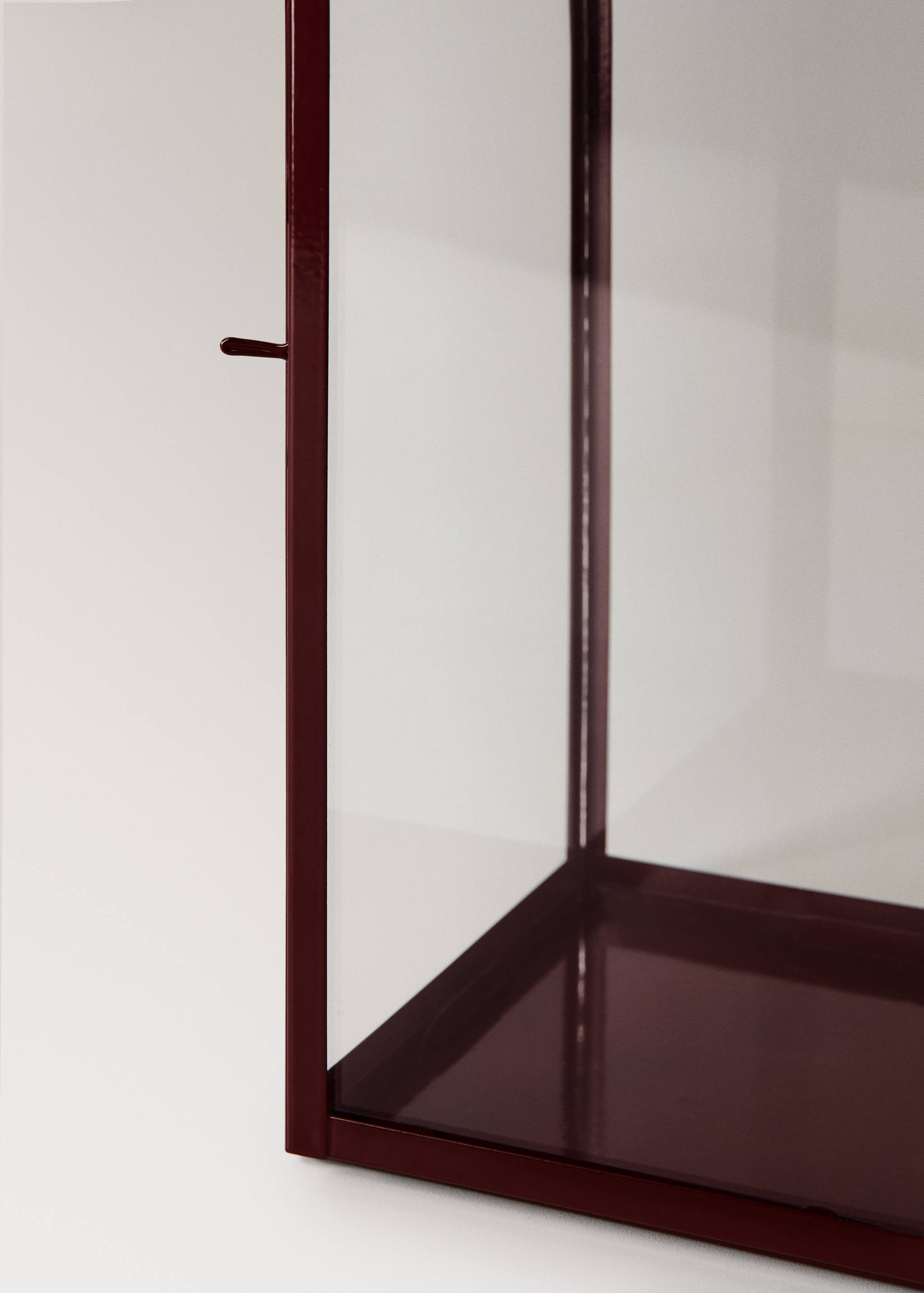 Burgundy metal and glass candle holder detail.