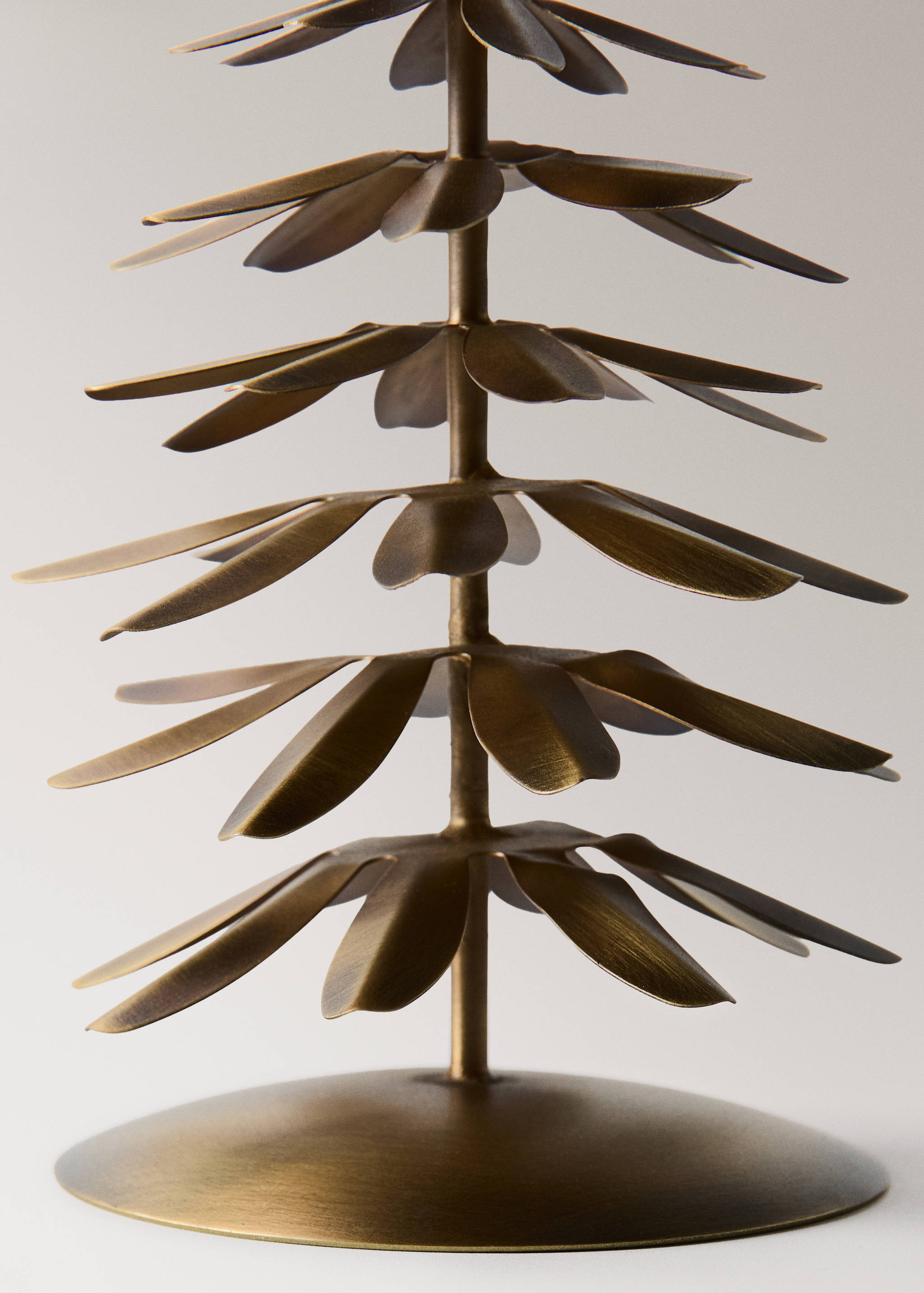 Portavelas de metal en tono bronce con forma de árbol estilizado de ramas con pétalos superpuestos.
