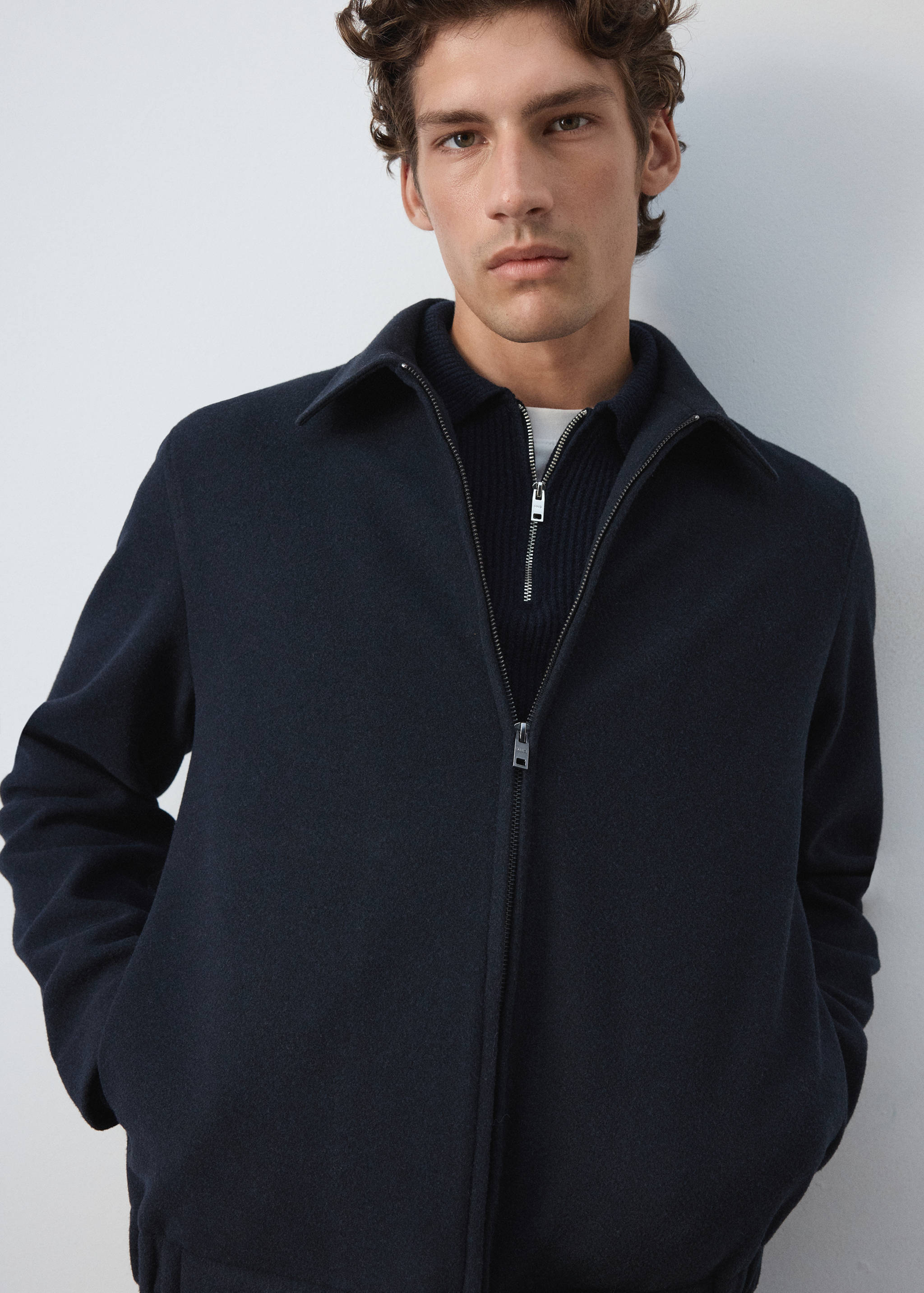 Dark navy blue zip-up sweatshirt with a collar, shown in a close-up portrait.