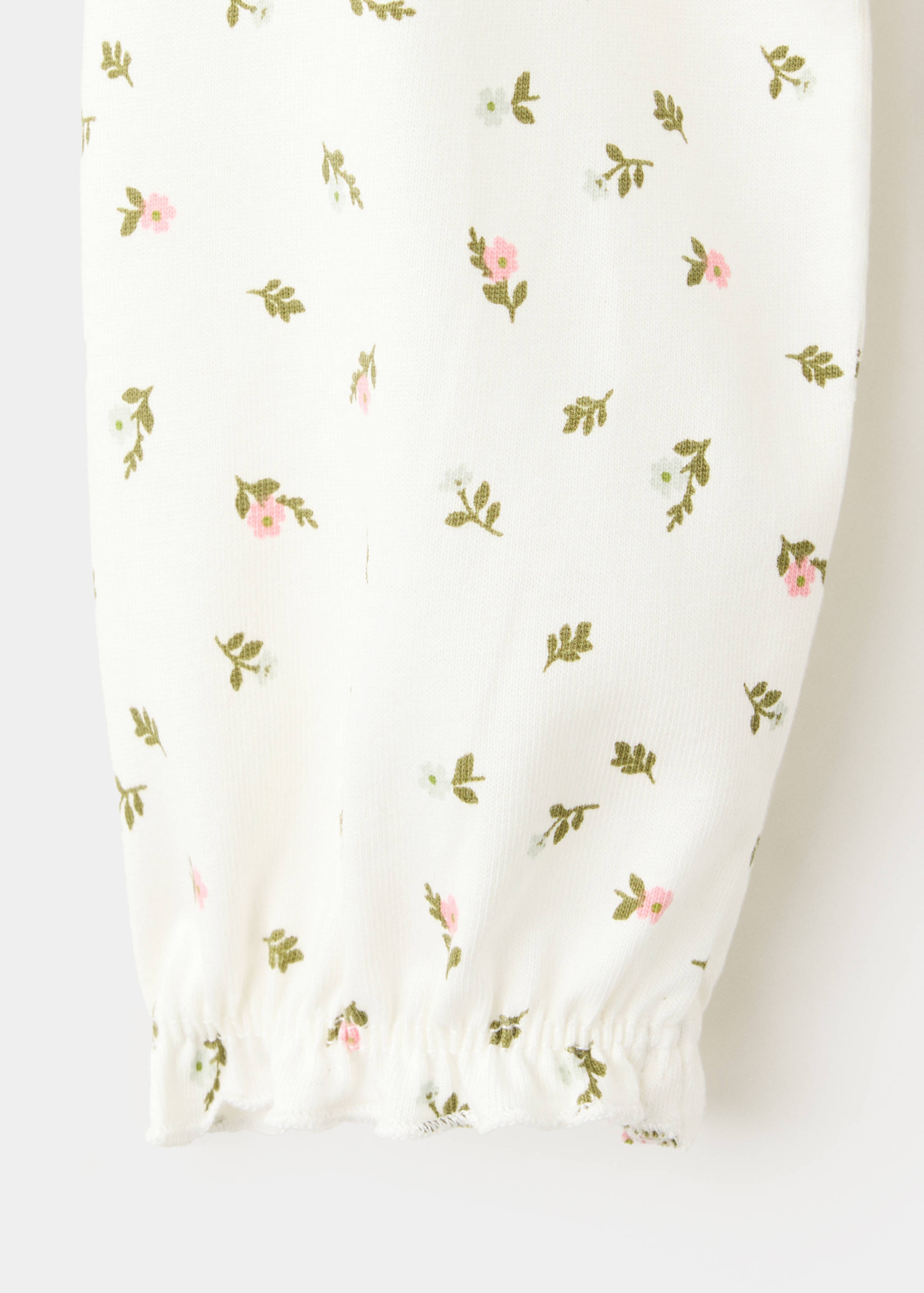 Close-up of a white t-shirt fabric with a pink and green floral print.