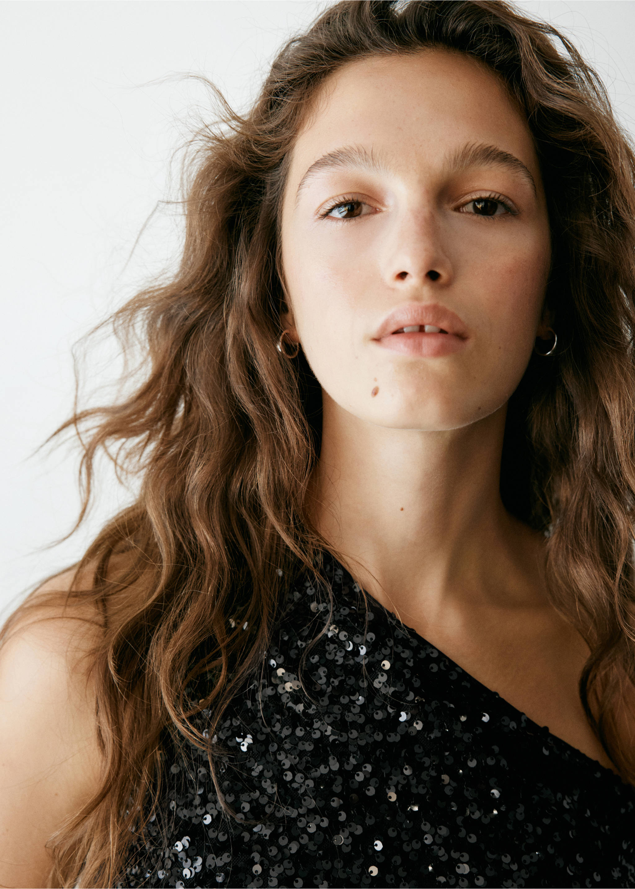 Close-up of a model wearing a black sequinned one-shoulder top., Black. Ref: 37007933-00.
