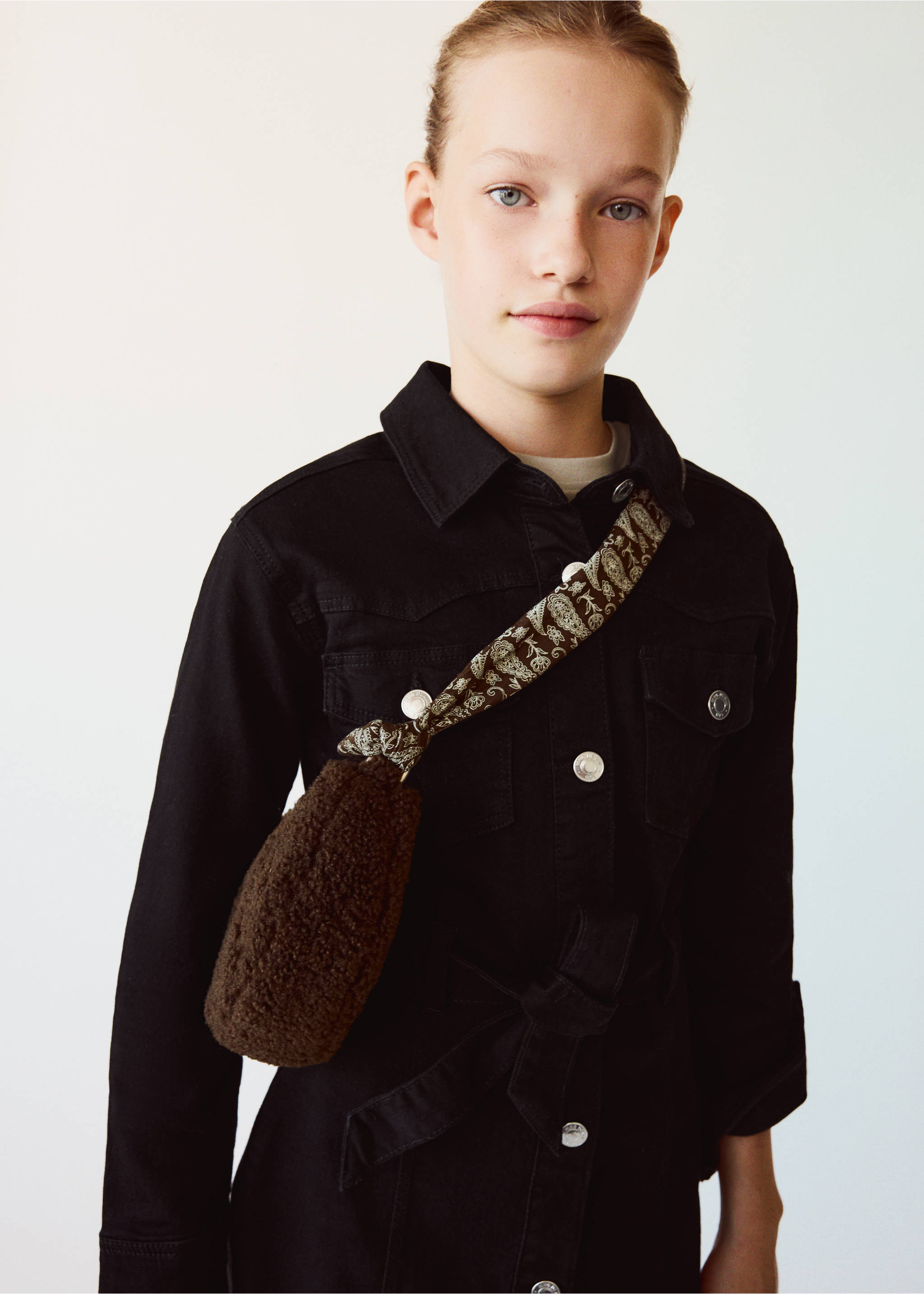 Brown faux-fur mini cross-body bag with a patterned strap worn by a young girl., Chocolate. Ref: 37007940-00.