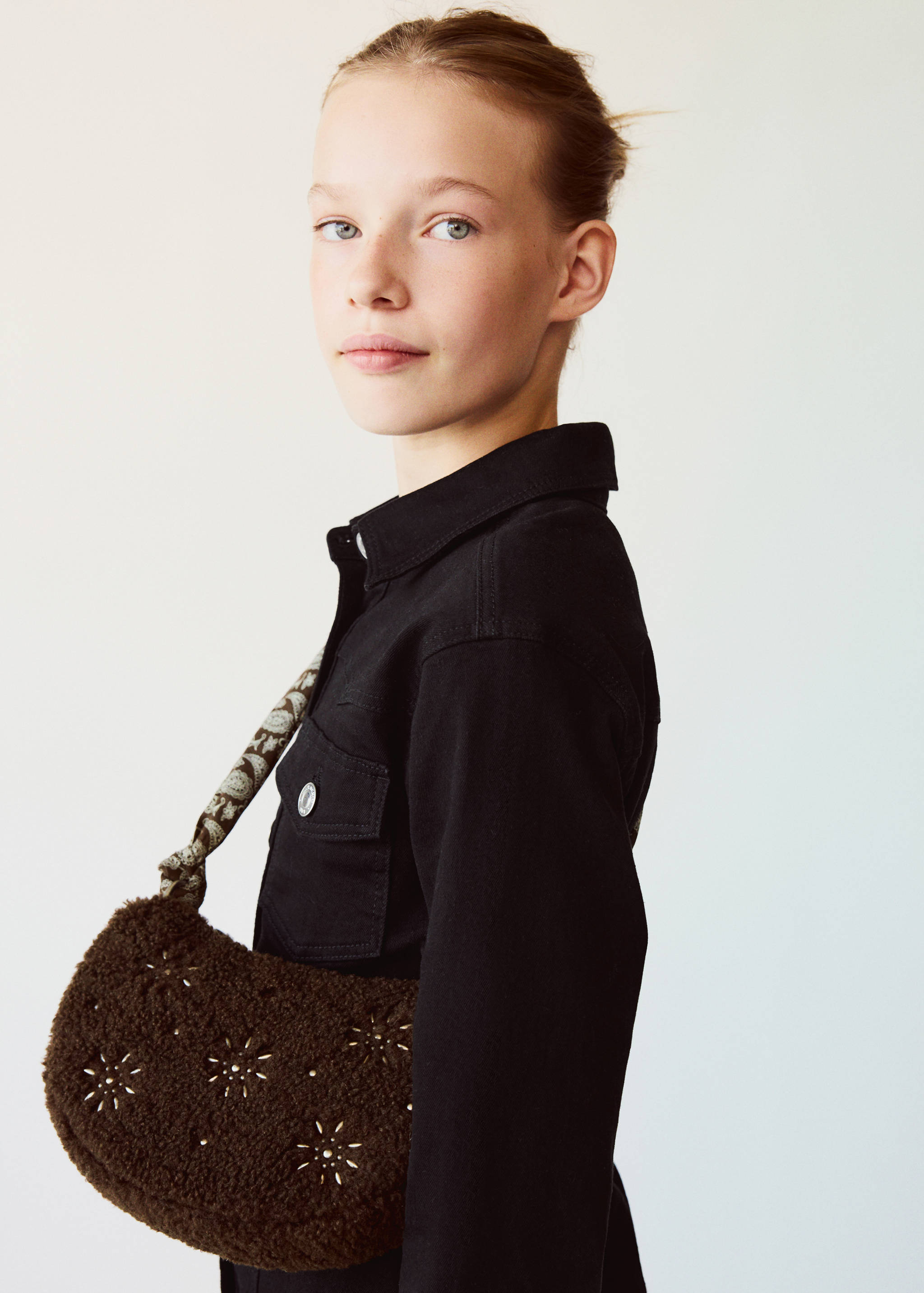 Brown faux-fur mini bag with embroidered floral motifs and patterned strap.