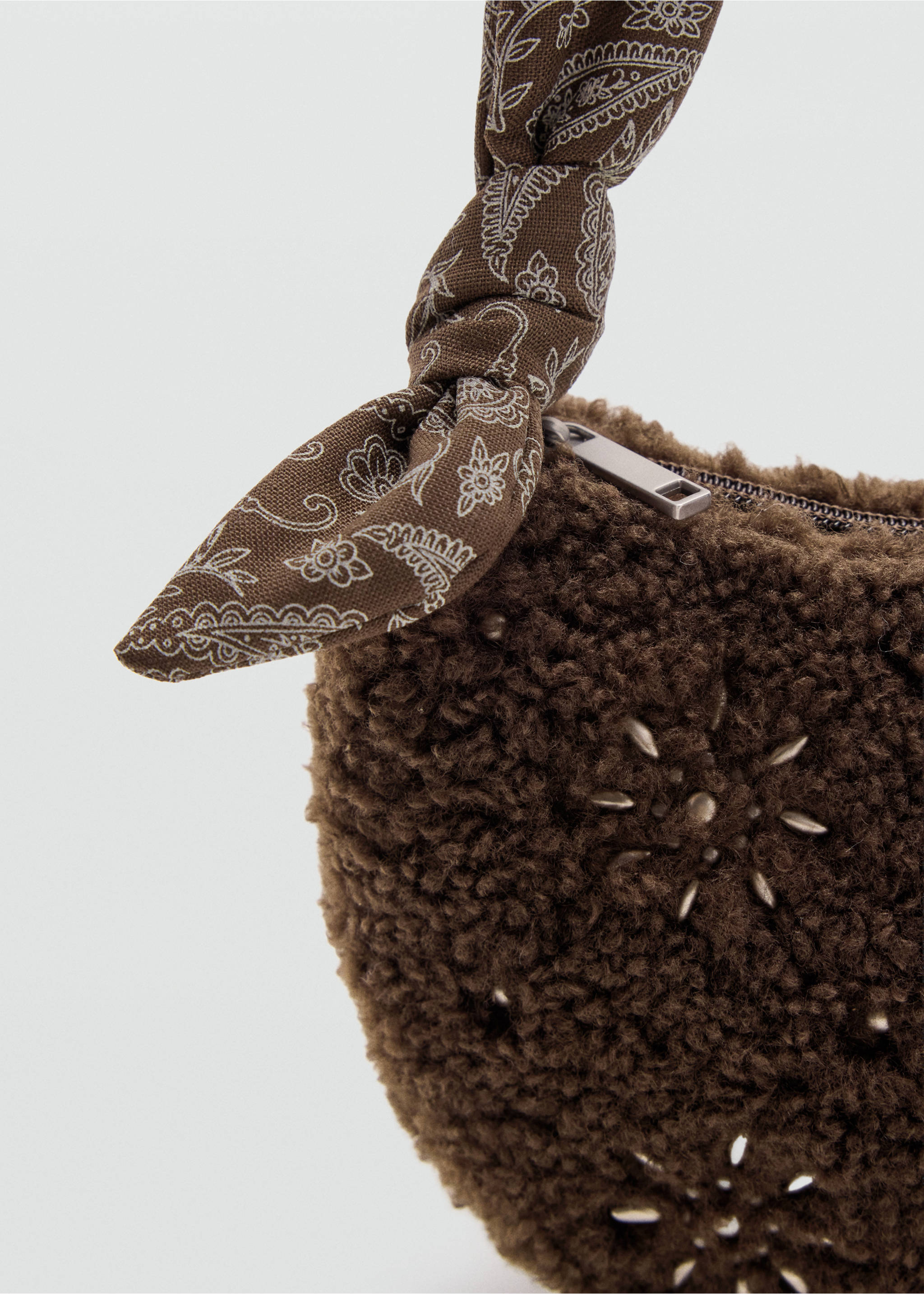 Close-up of a brown faux-fur mini bag with star studs and a knotted paisley strap., Chocolate. Ref: 37007940-00.