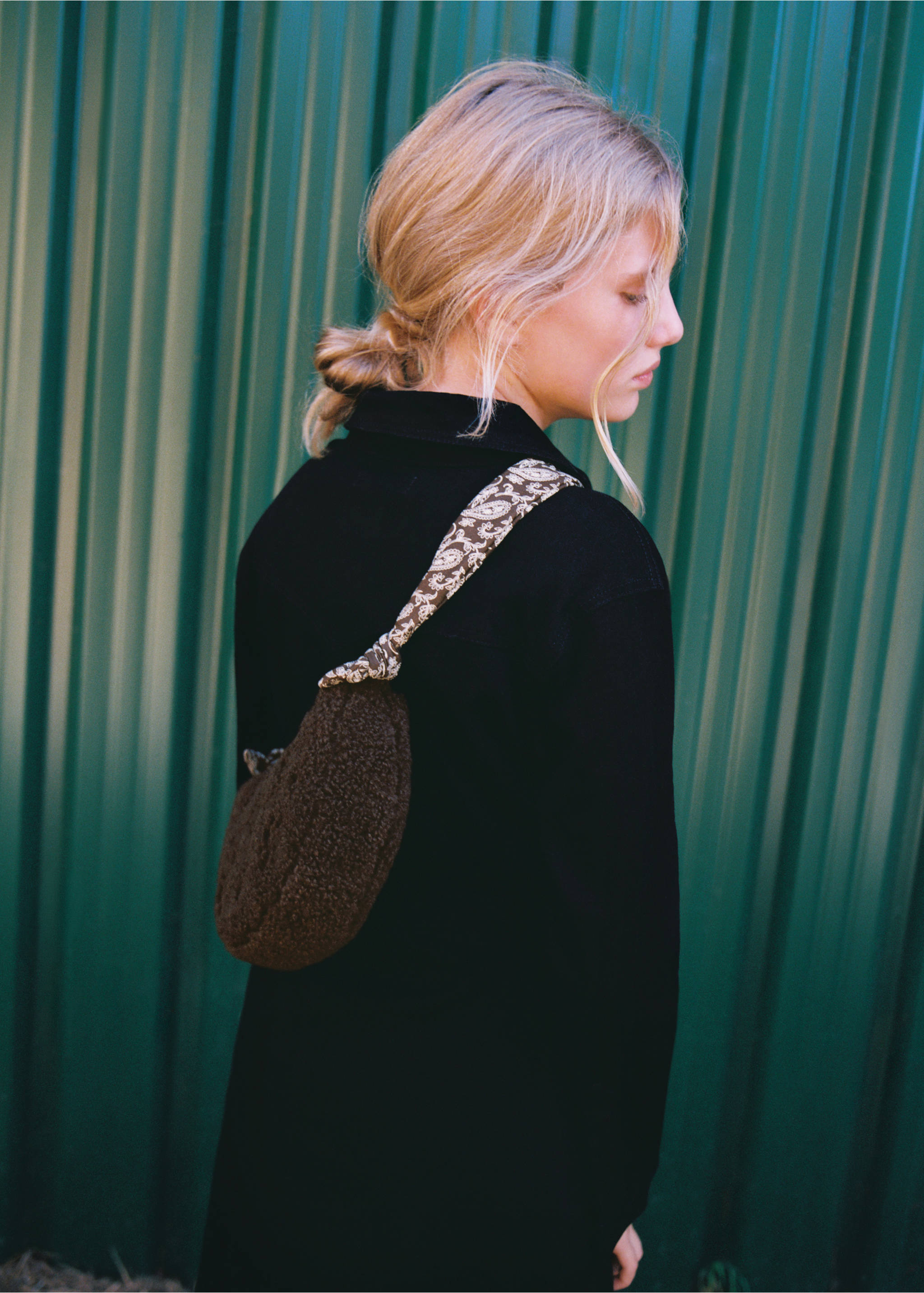 Brown faux-shearling mini bag with a patterned strap worn by a model in a dark coat., Chocolate. Ref: 37007940-00.