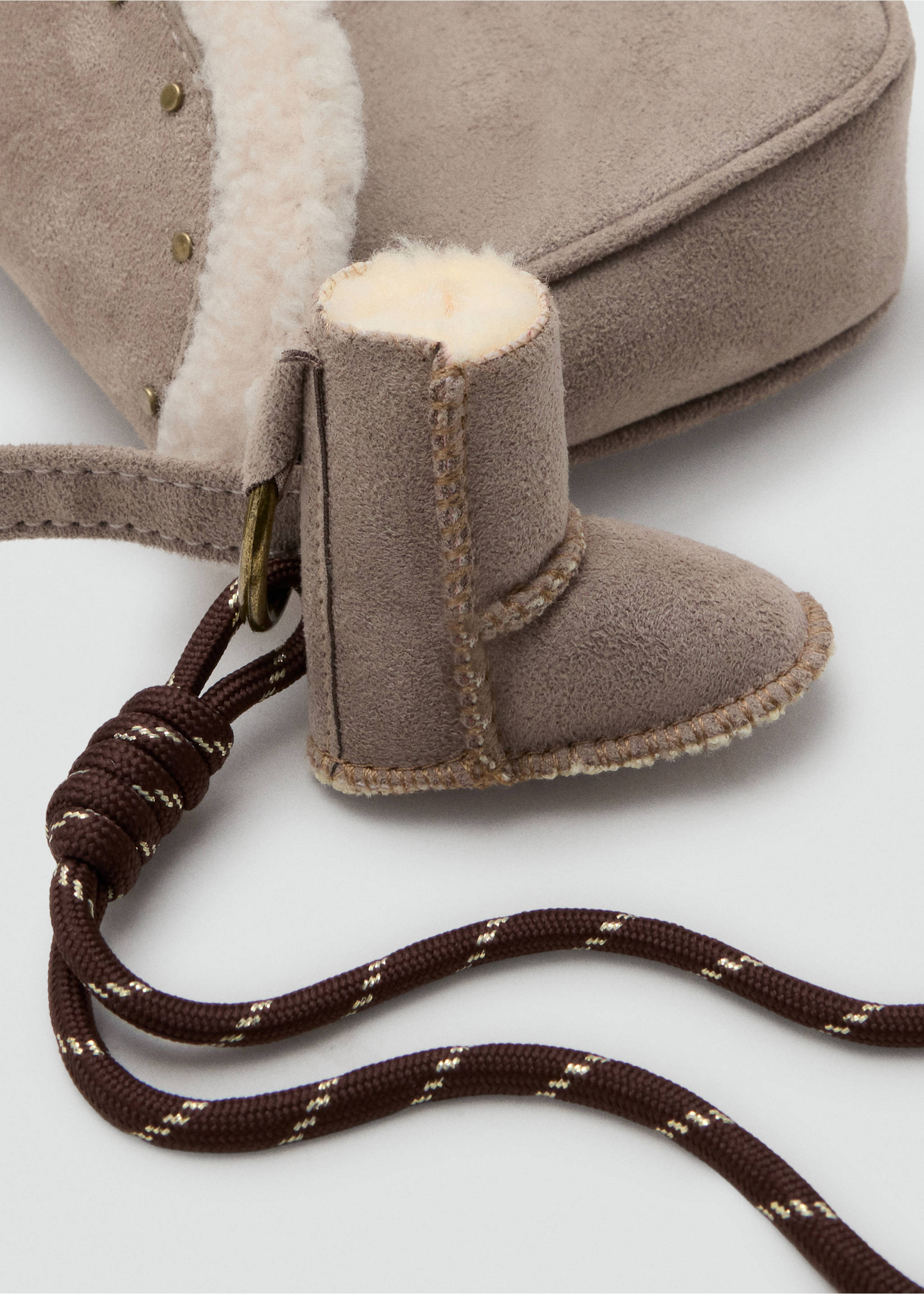Close-up of a grey mini bag with faux-shearling trim and a miniature boot charm., Ice Grey. Ref: 37007941-00.