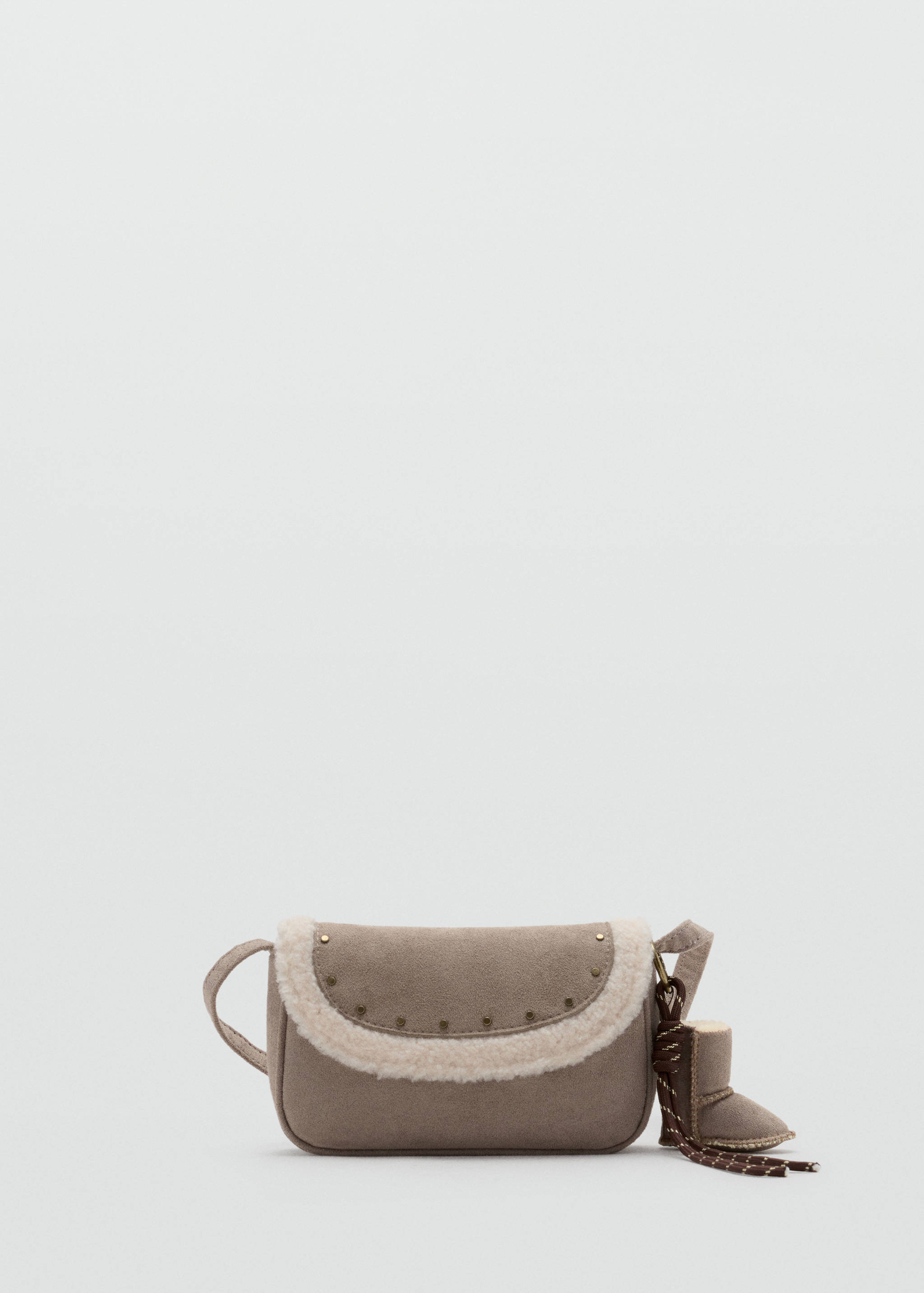 Taupe mini crossbody bag with white faux-shearling trim, metallic studs, and a matching miniature boot charm.