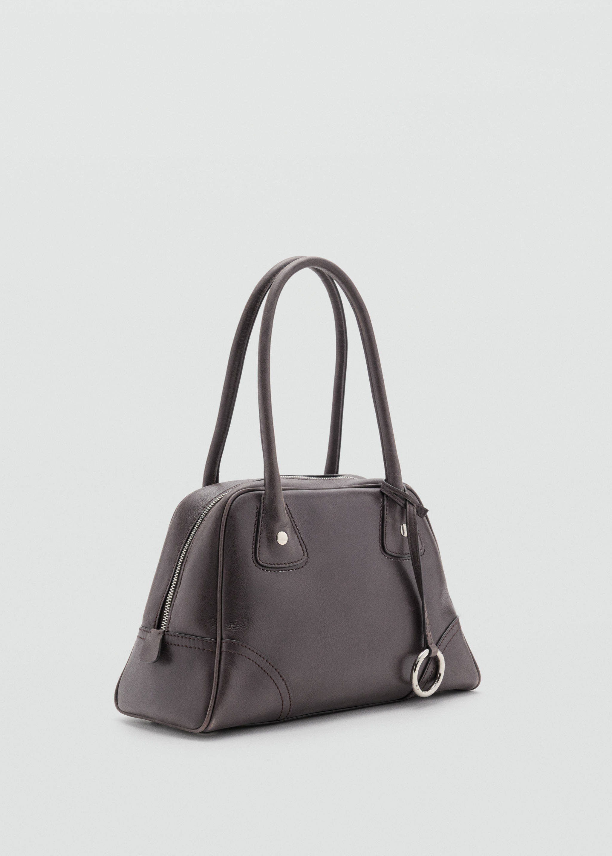 Dark brown bowling bag with top handles, zip closure, and circular silver ring charm.