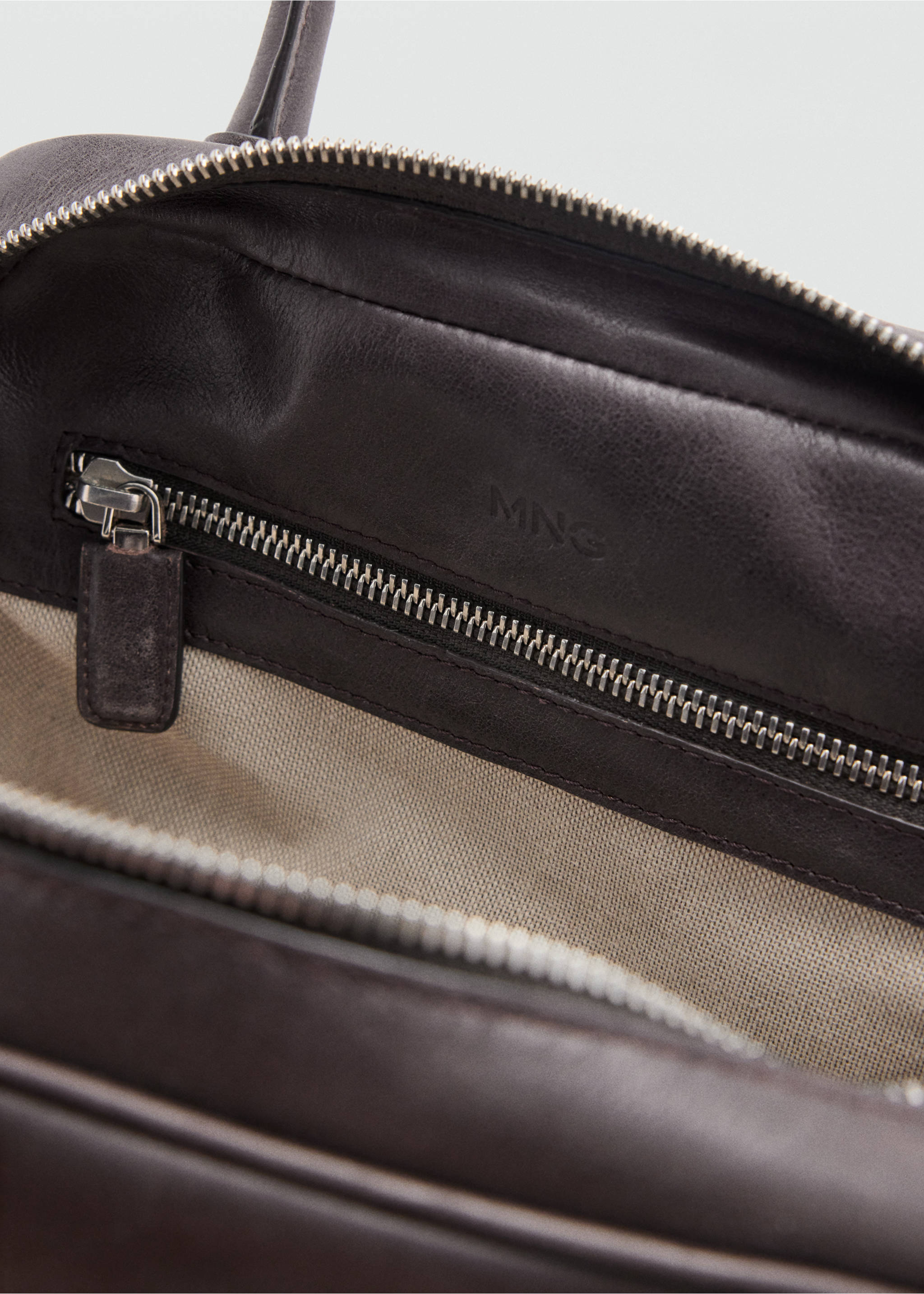 Close-up interior detail of the dark brown bowling bag showing the fabric lining and zippered pocket., Chocolate. Ref: 37007943-00.