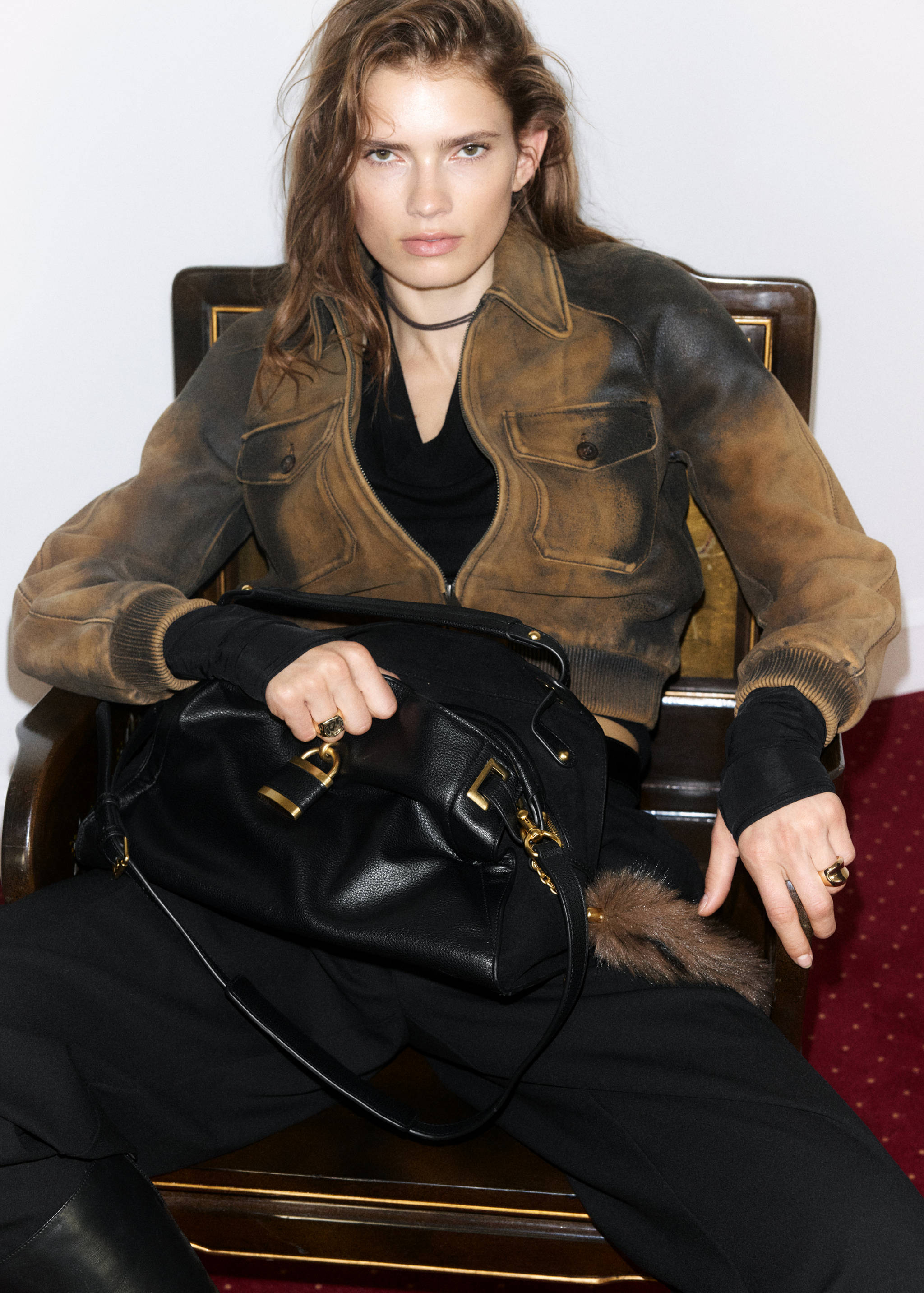 Black leather shoulder bag with gold-tone hardware and padlock detail.