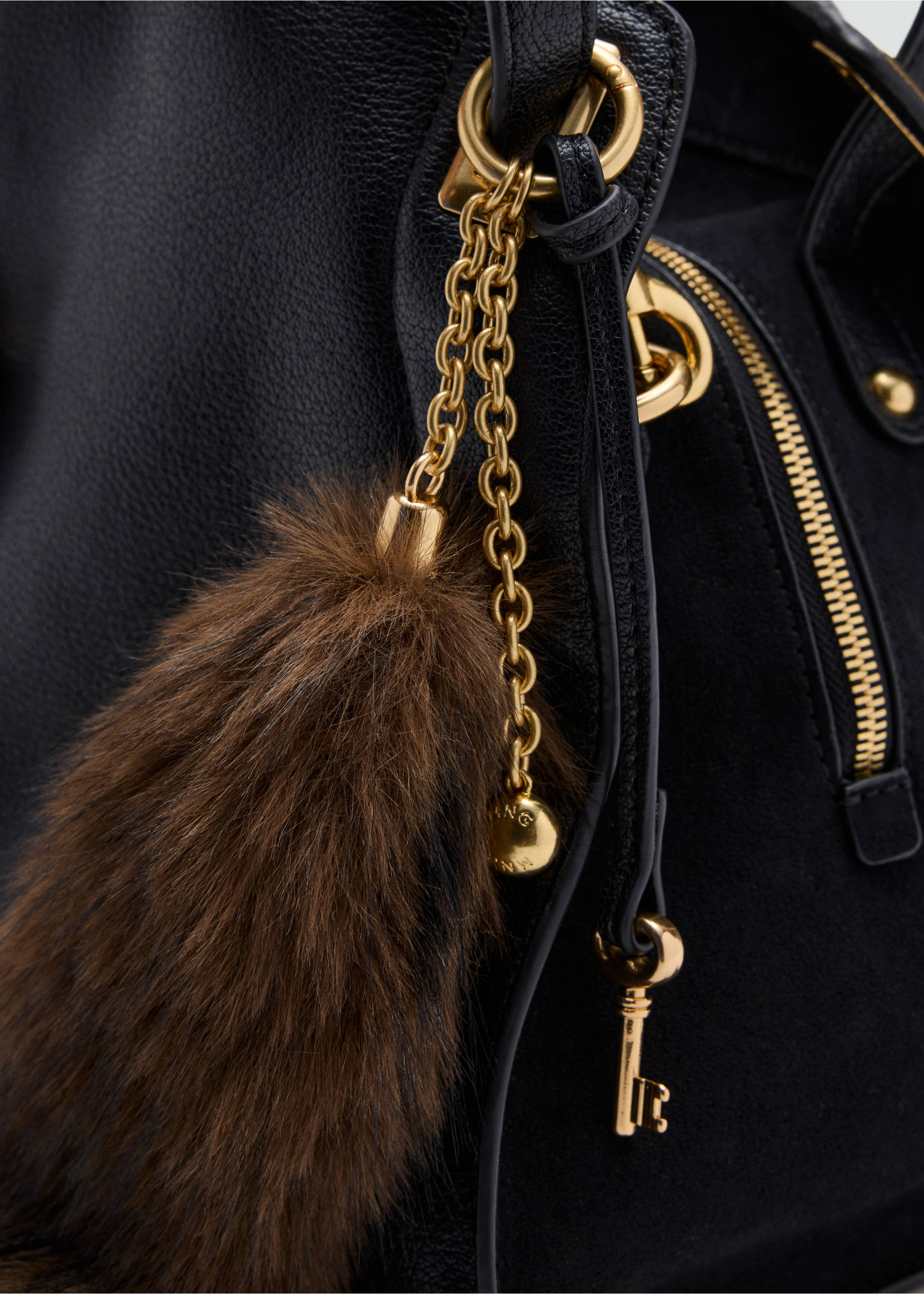 Black shoulder bag detail with a brown faux-fur charm and gold hardware., Black. Ref: 37007945-00.