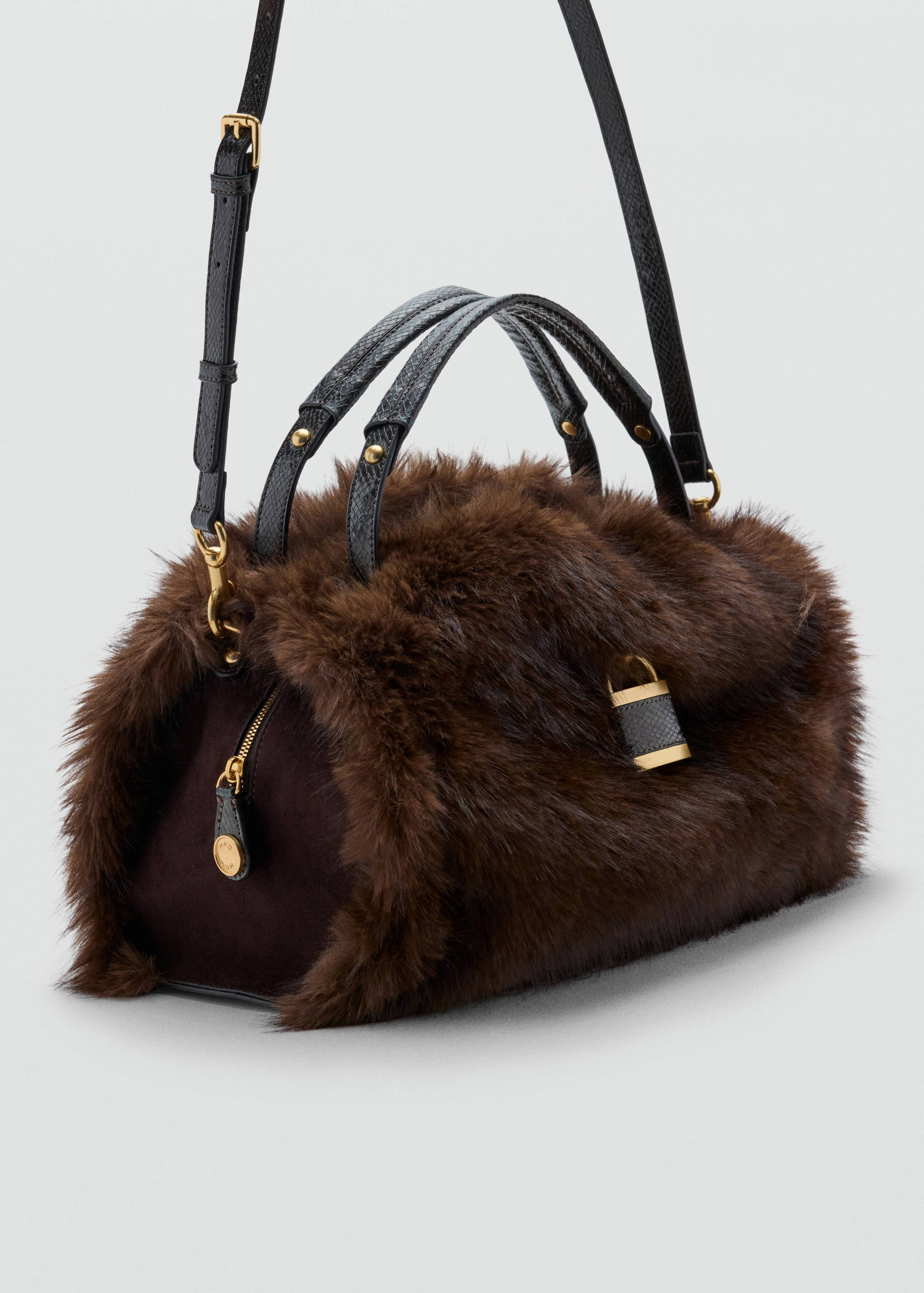 Brown faux-fur cylindrical shoulder bag with black leather handles and gold hardware.