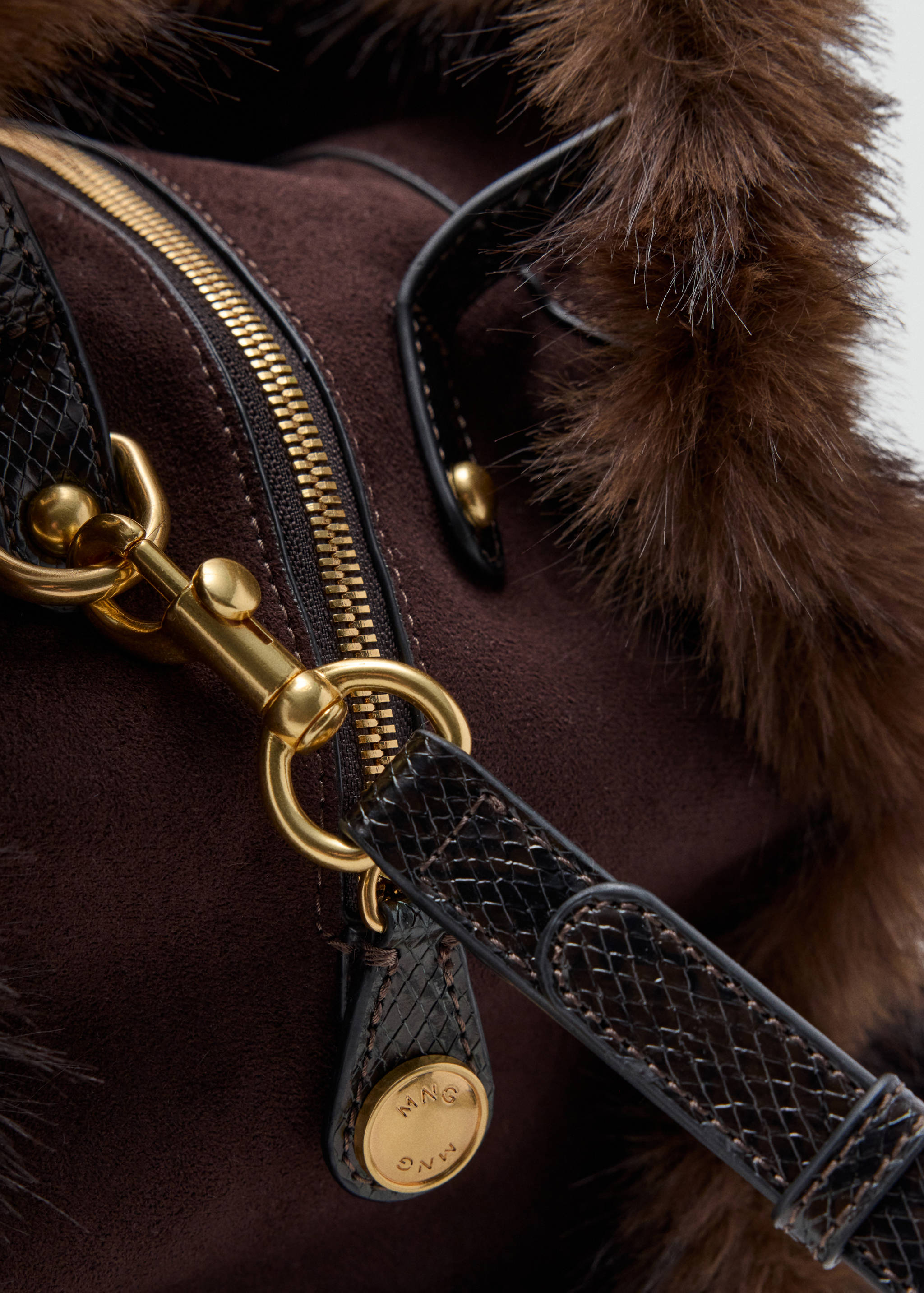 Close-up of brown suede shoulder bag with faux-fur trim and gold hardware.