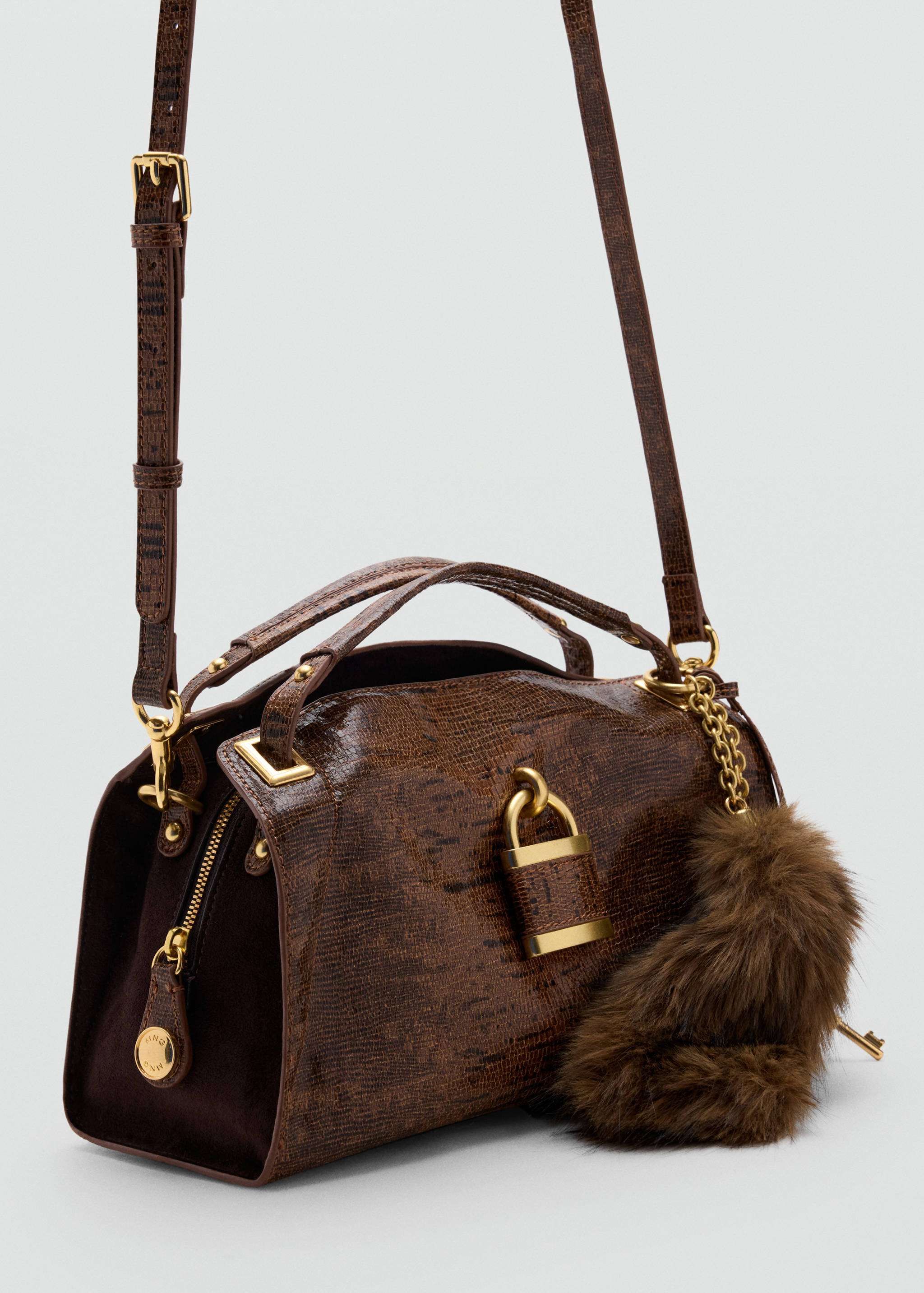 Brown embossed crossbody bag with top handles, gold padlock hardware and a faux-fur charm.