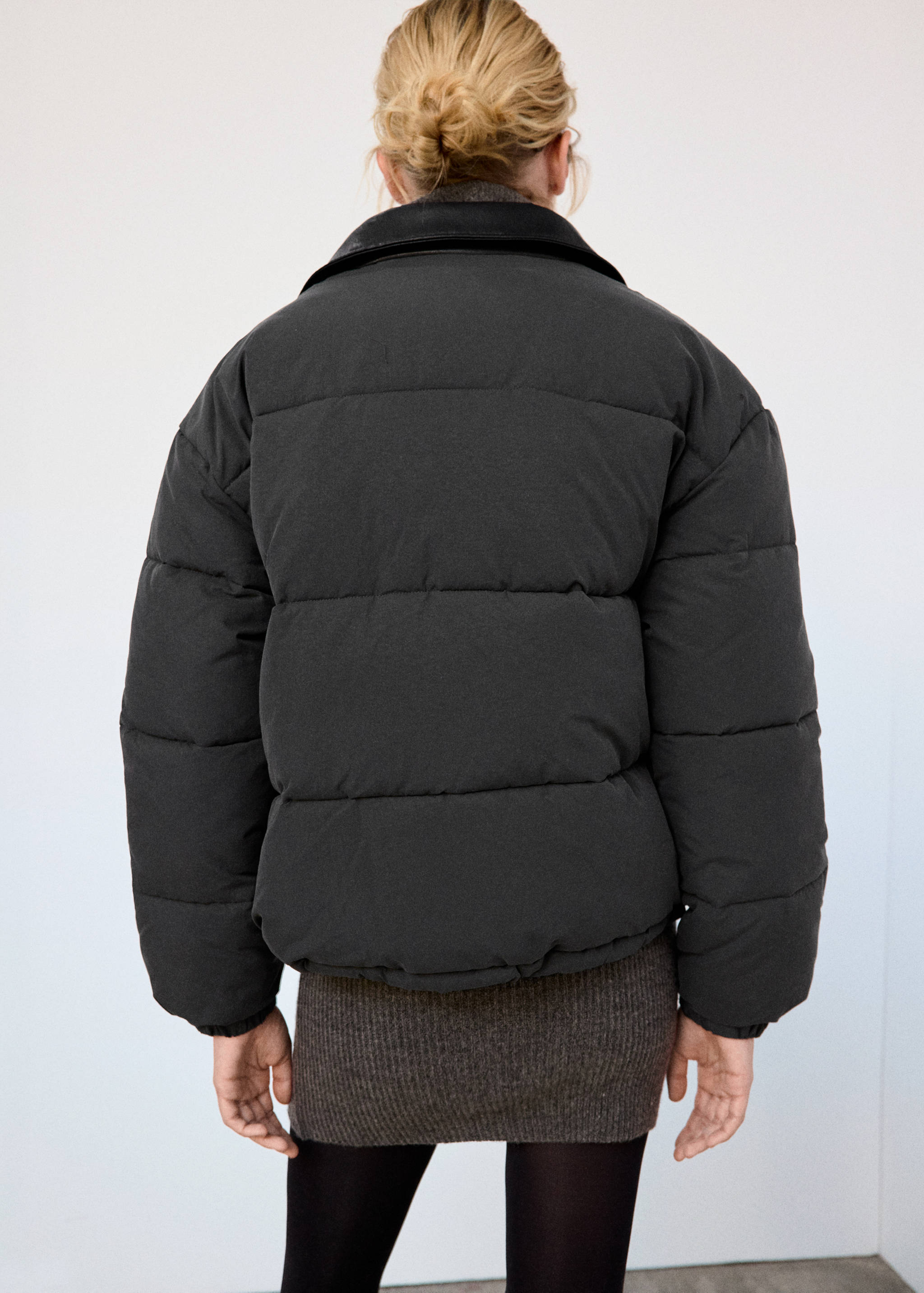 Dark grey quilted anorak with a contrasting collar, back view.