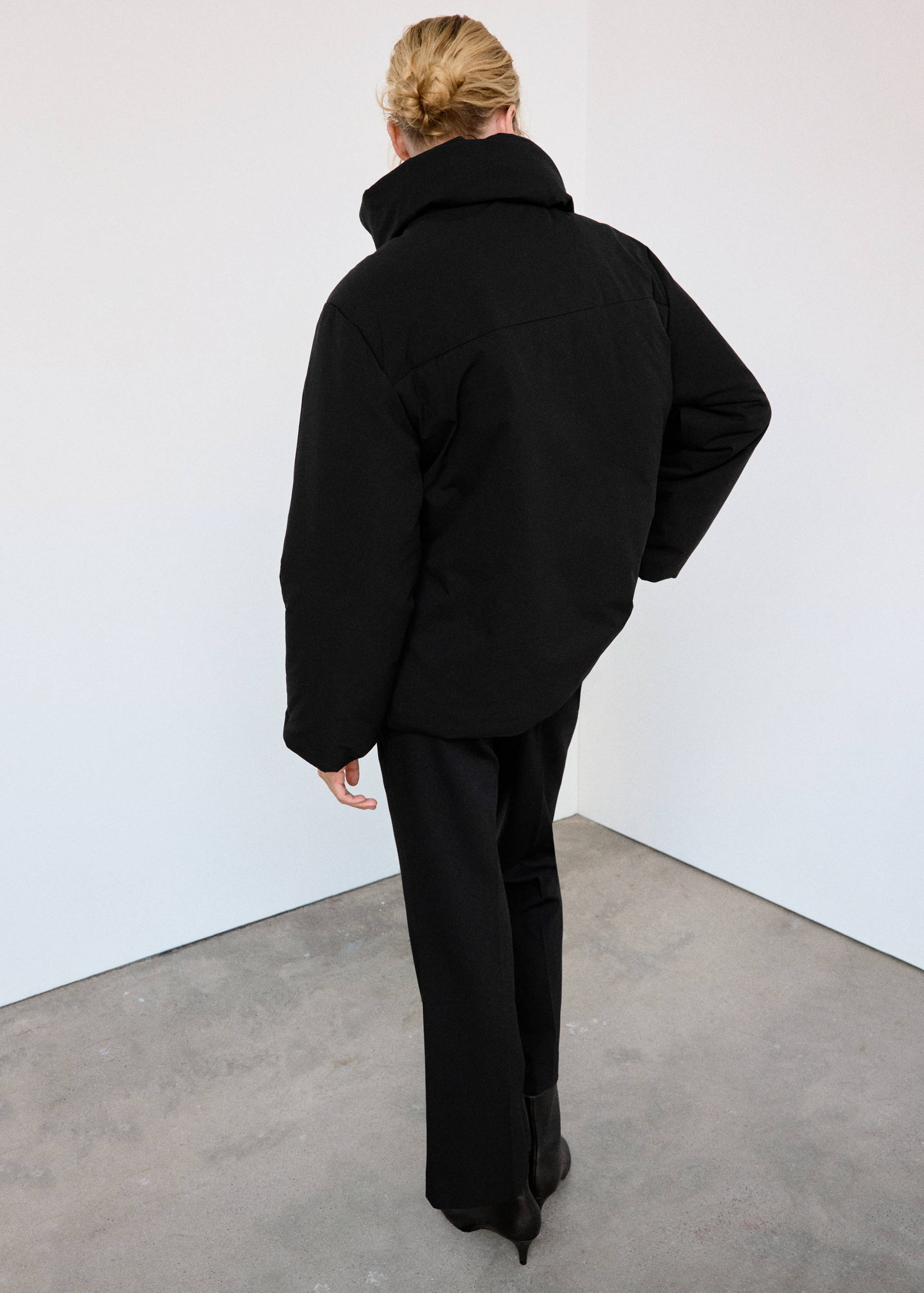 Black anorak with a high collar, shown from the back.