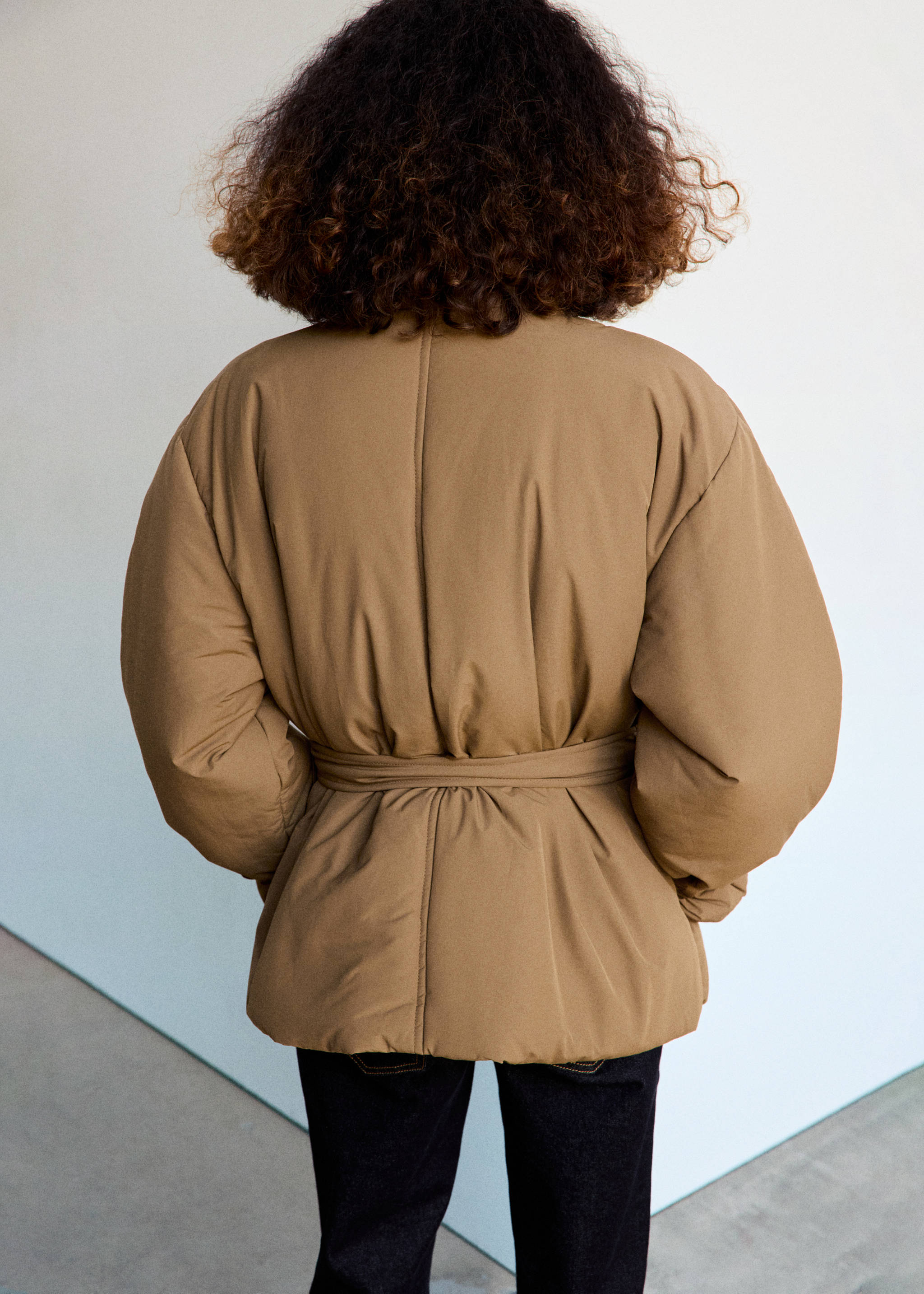 Camel brown anorak, back view, featuring a matching waist belt and peplum hem.