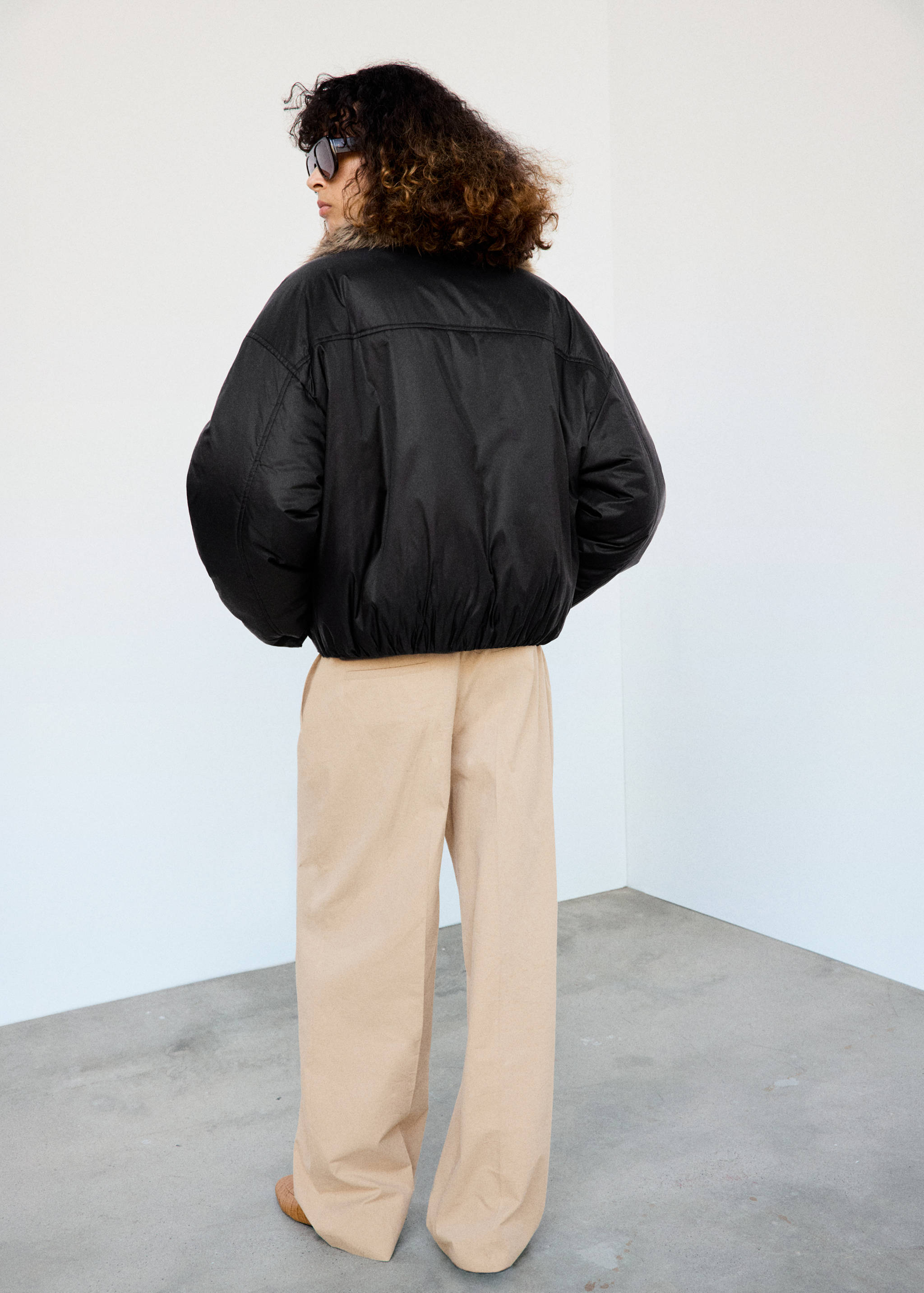 Black cropped anorak with a faux-fur collar, seen from the back.