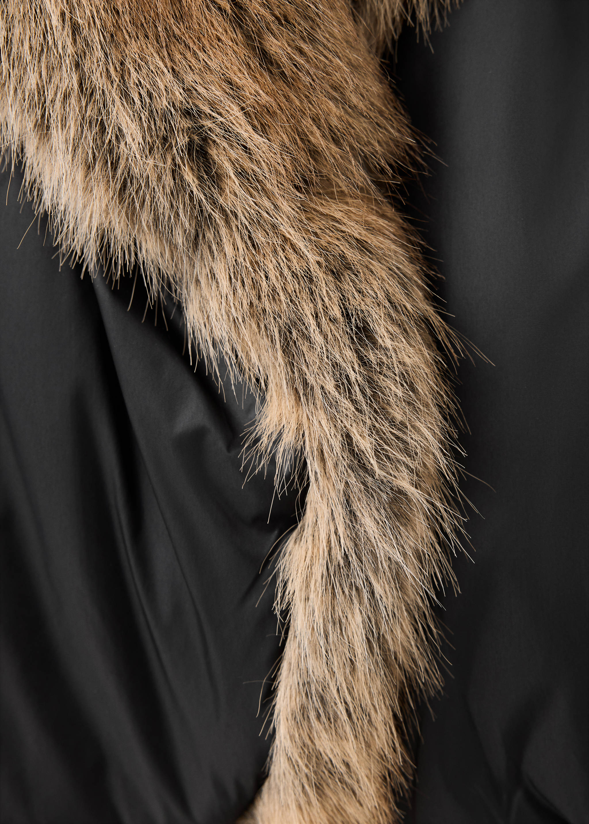 Close-up of a black anorak with brown faux-fur trim.