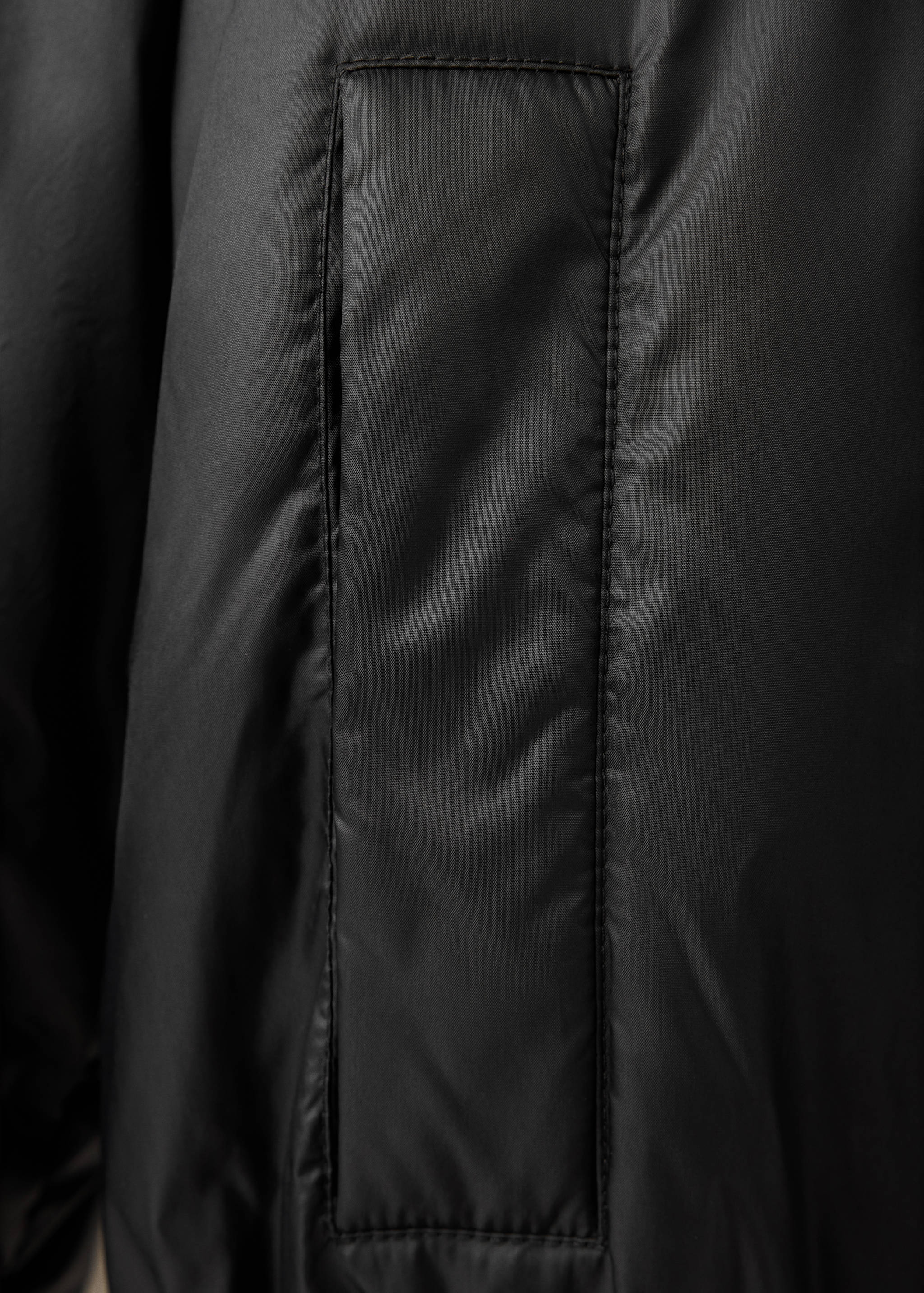 Close-up of the black anorak fabric and panel detail.
