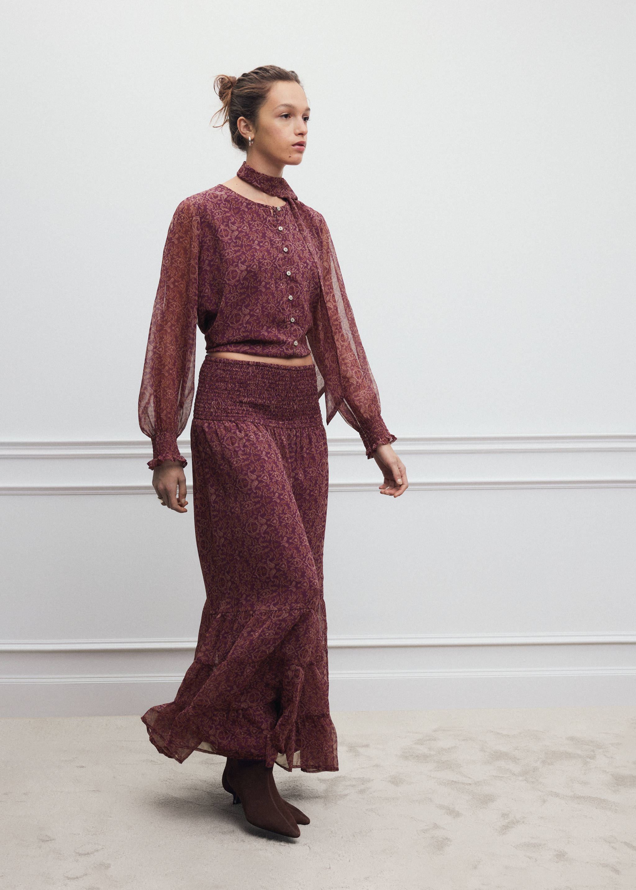 Dark red patterned long-sleeve shirt with matching necktie, worn with a matching midi skirt.