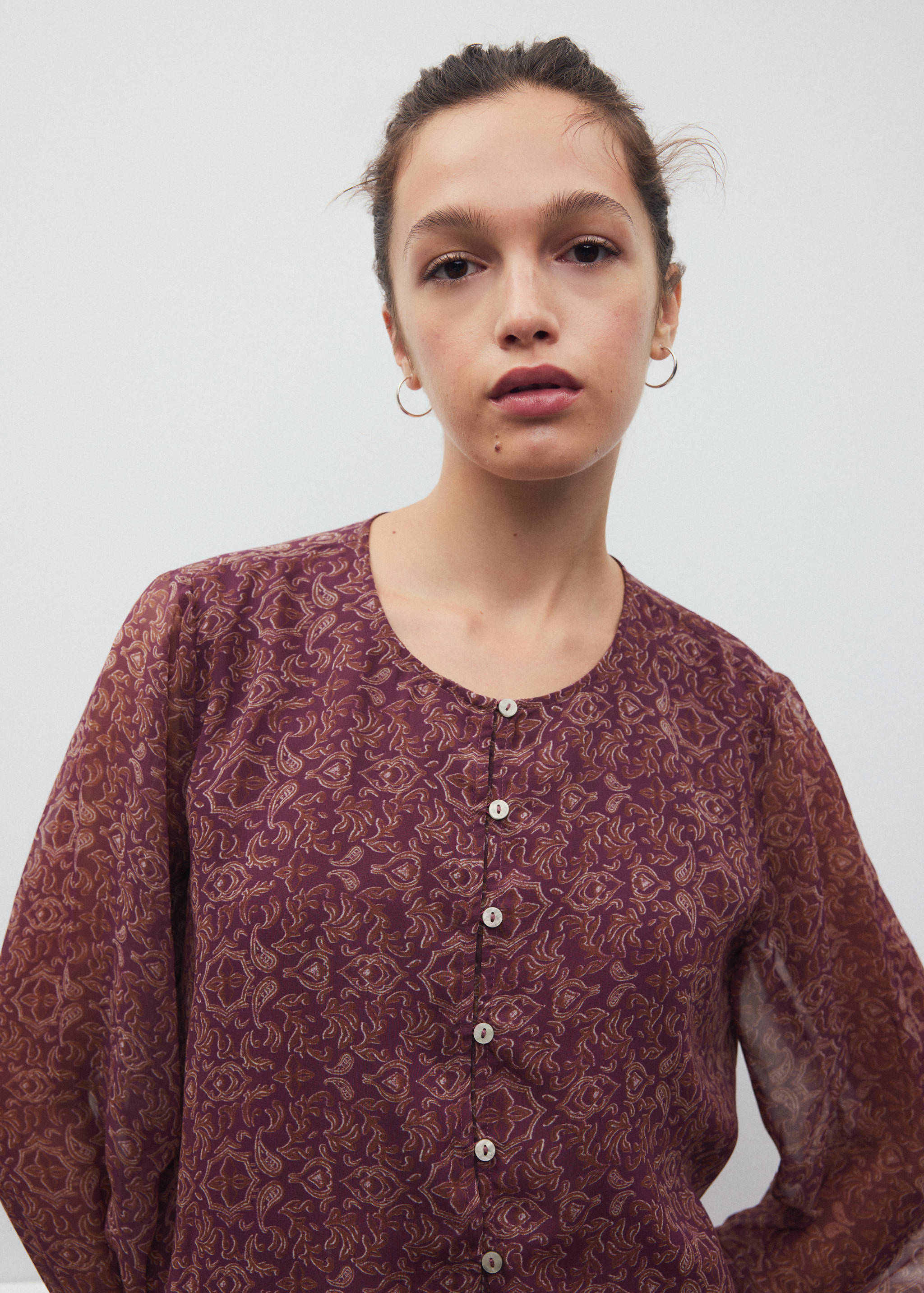 Plum paisley print shirt with a round neckline and button fastening.