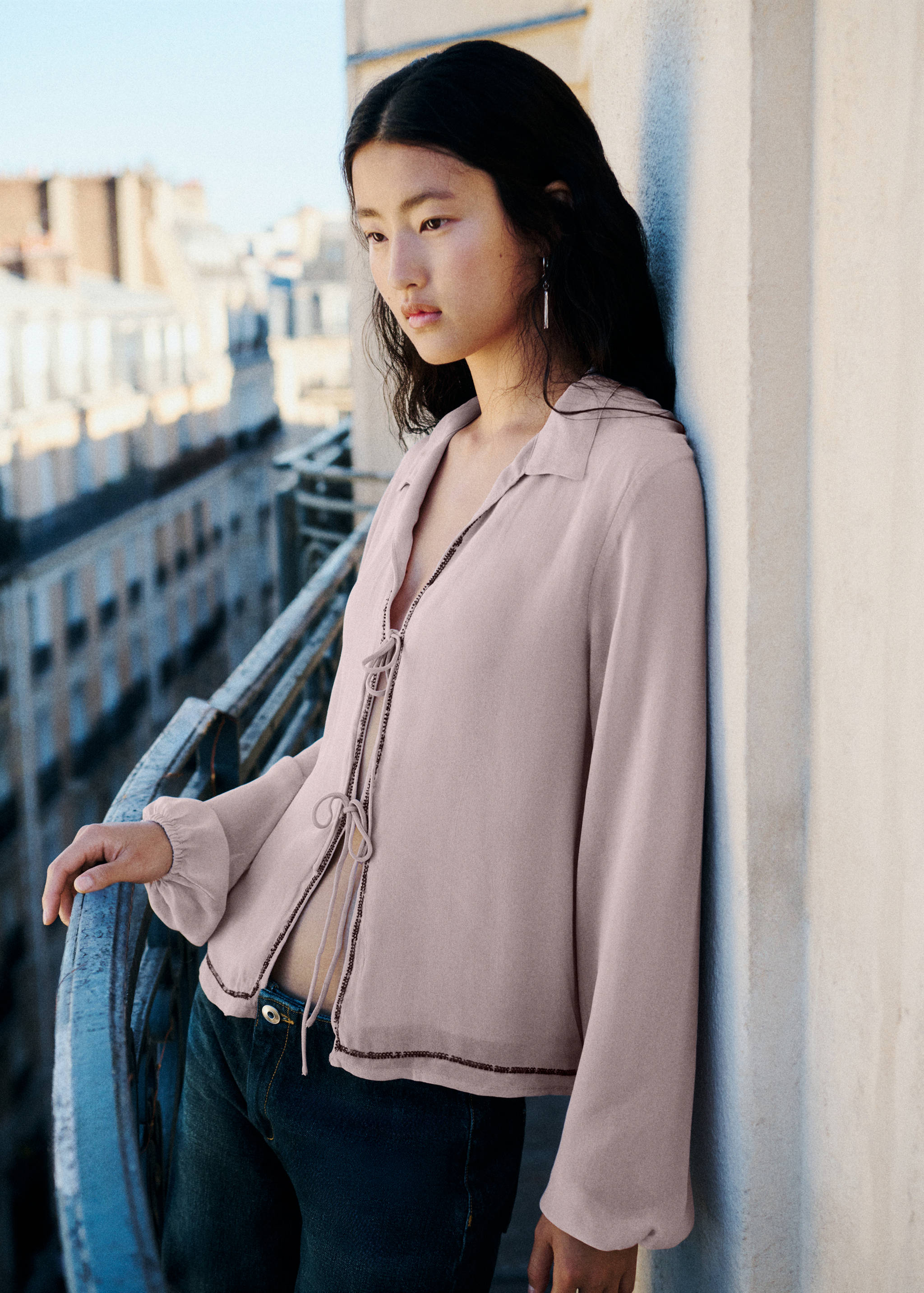 Pale pink shirt with tie front closure and beaded trim.