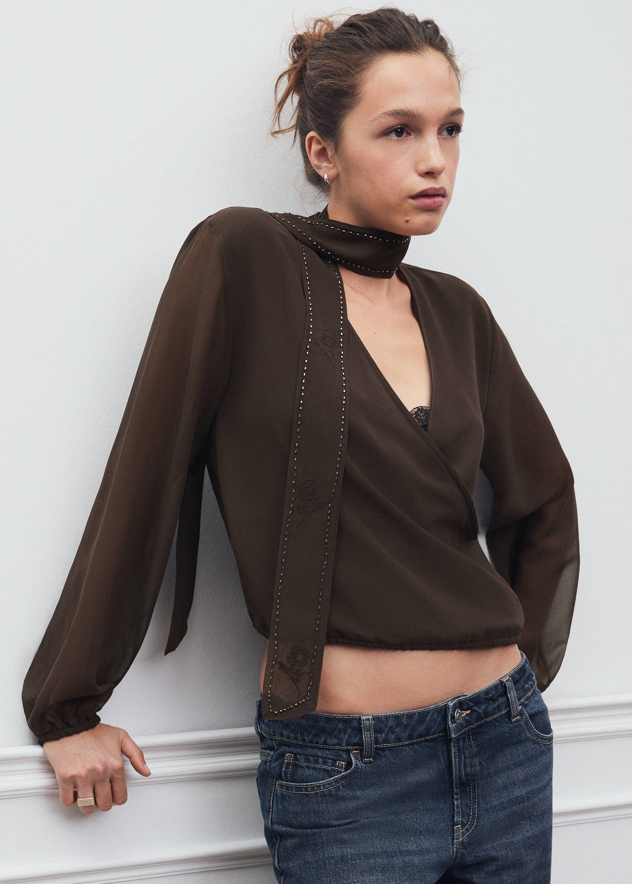 Dark brown wrap blouse with long sleeves, matching studded scarf and V-neck.